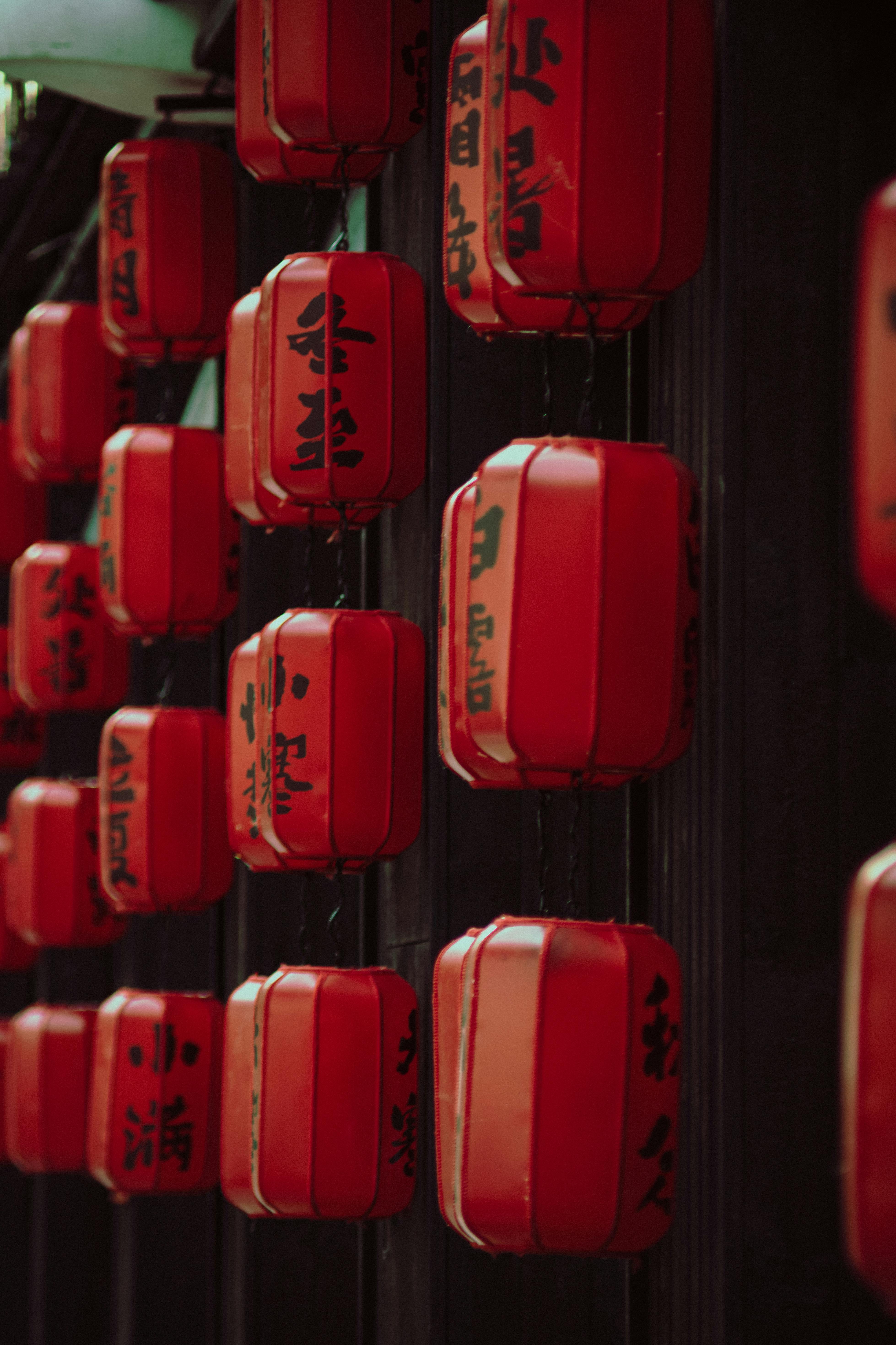 Ücretsiz Üzerlerinde siyah hat yazıları bulunan parlak kırmızı Çin fenerleri sıra halinde asılı duruyor. Stok Fotoğraflar