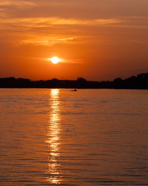 Free Peaceful sunset over the Ottawa River with reflection in calm waters. Stock Photo