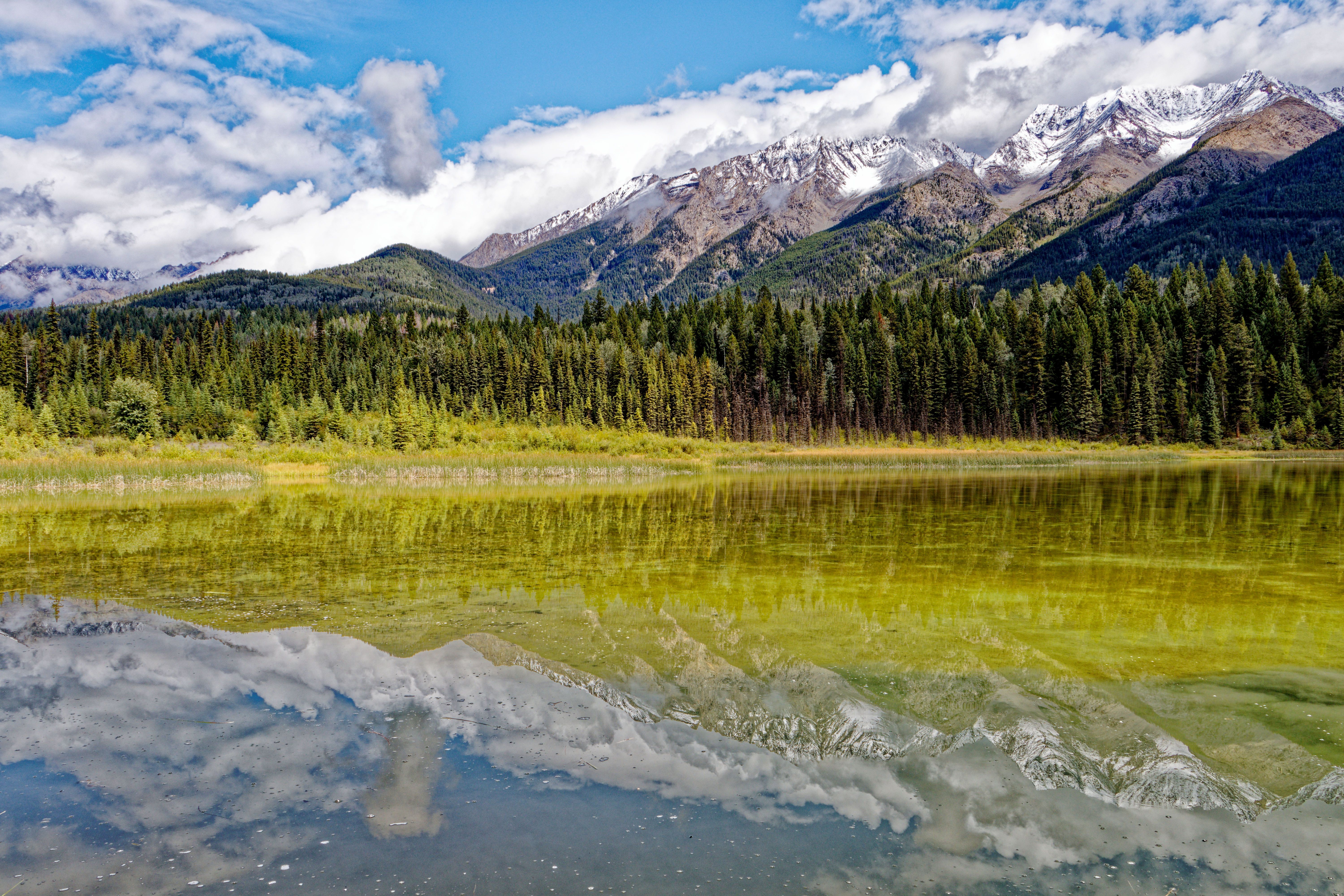 Majestic view of the Canadian Rockies reflecting in a tranquil lake in British Columbia.