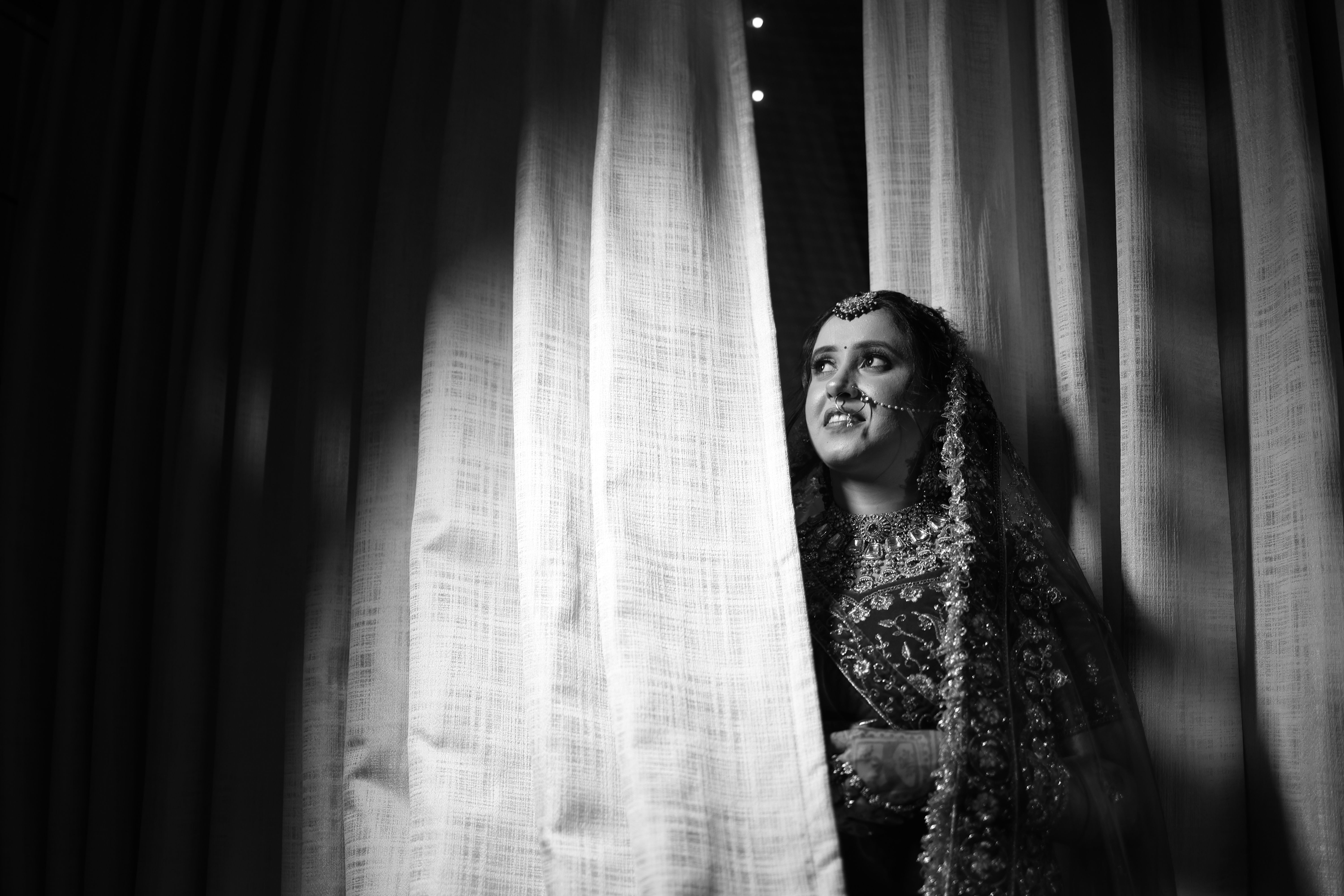 Captivating black and white photo of a bride in traditional attire with intricate details.
