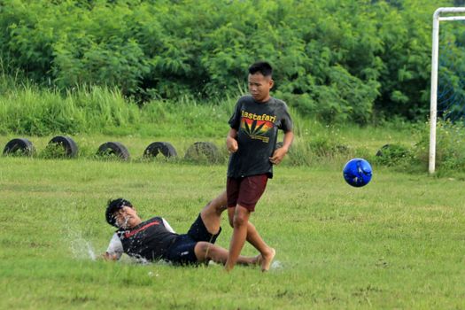 Two teenagers engage in a lively soccer match on a grassy field, showcasing action and sportsmanship.