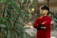 Young Boy in Red Attire in a Serene Garden Setting