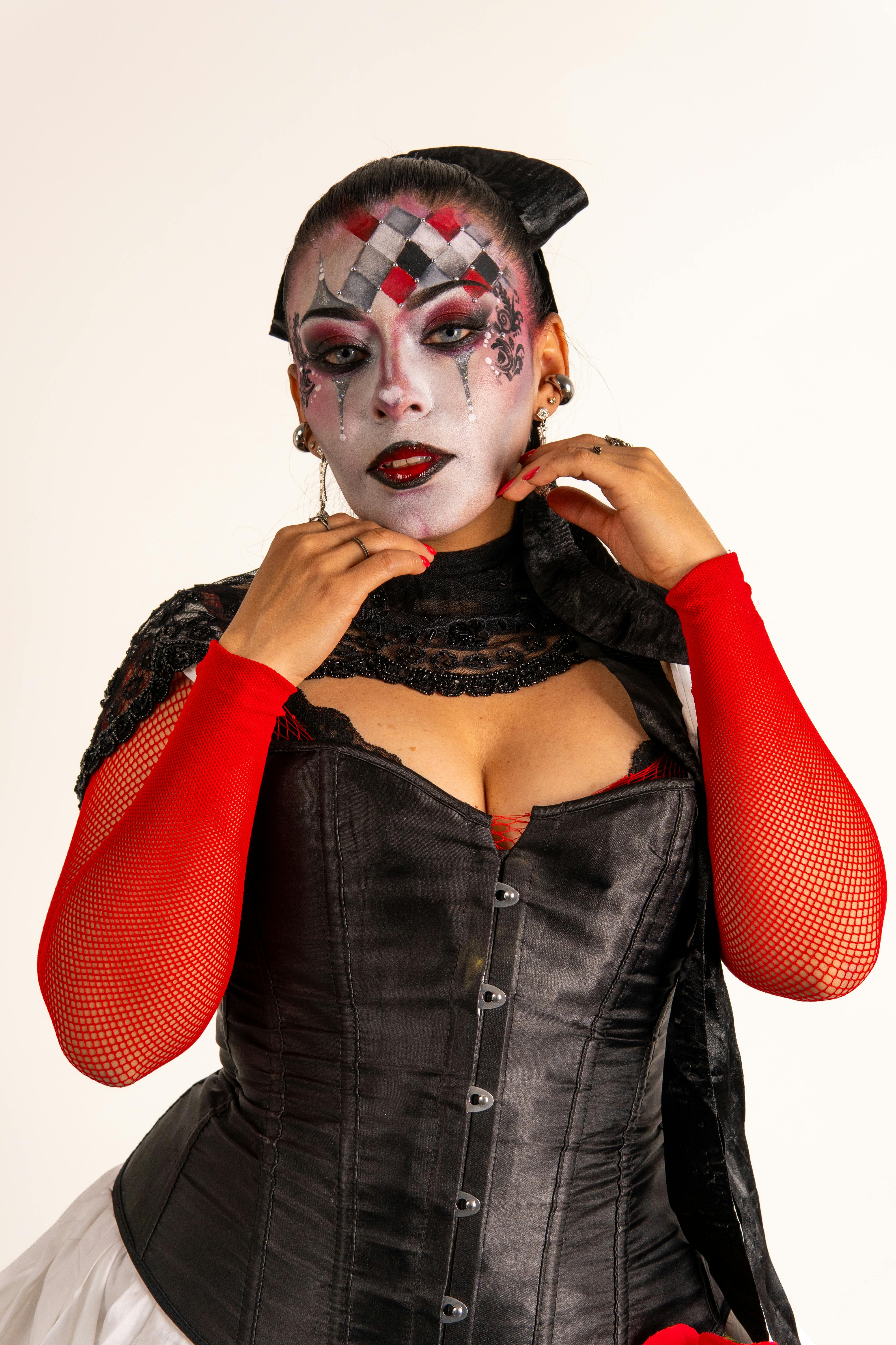 Ücretsiz Siyah ve kırmızı kıyafetler giymiş Latin bir kadının canlı palyaço makyajıyla yapılmış portresi. Stok Fotoğraflar