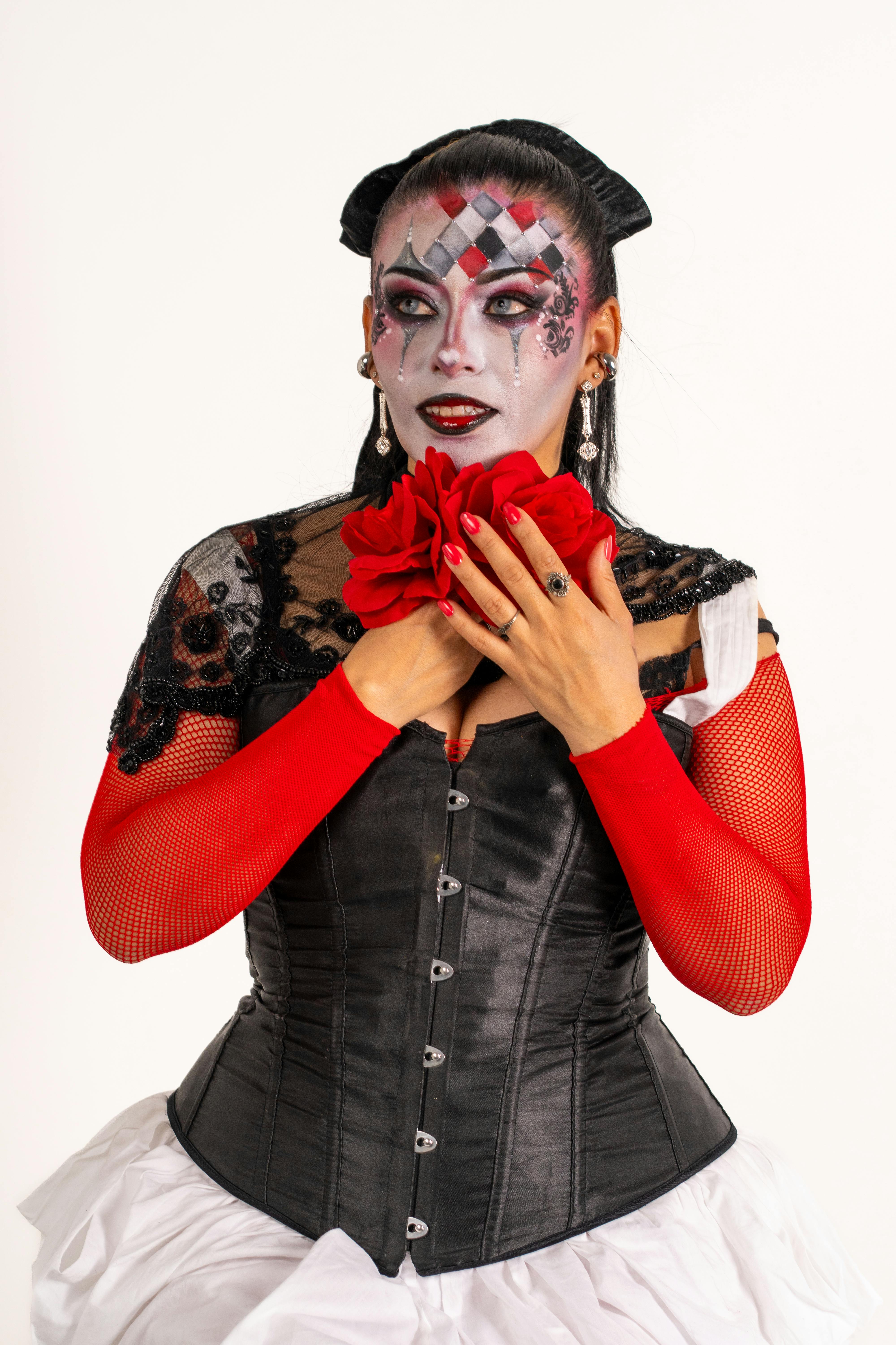 Gratis Wanita Latina yang menawan dengan riasan dan kostum ala harlequin, menangkap semangat karnaval yang semarak. Foto Stok