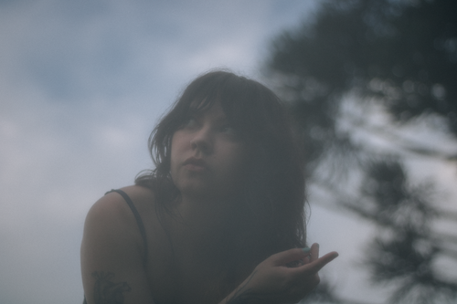 Free Artistic portrait of a woman in a misty setting, conveying mystery and intrigue. Stock Photo