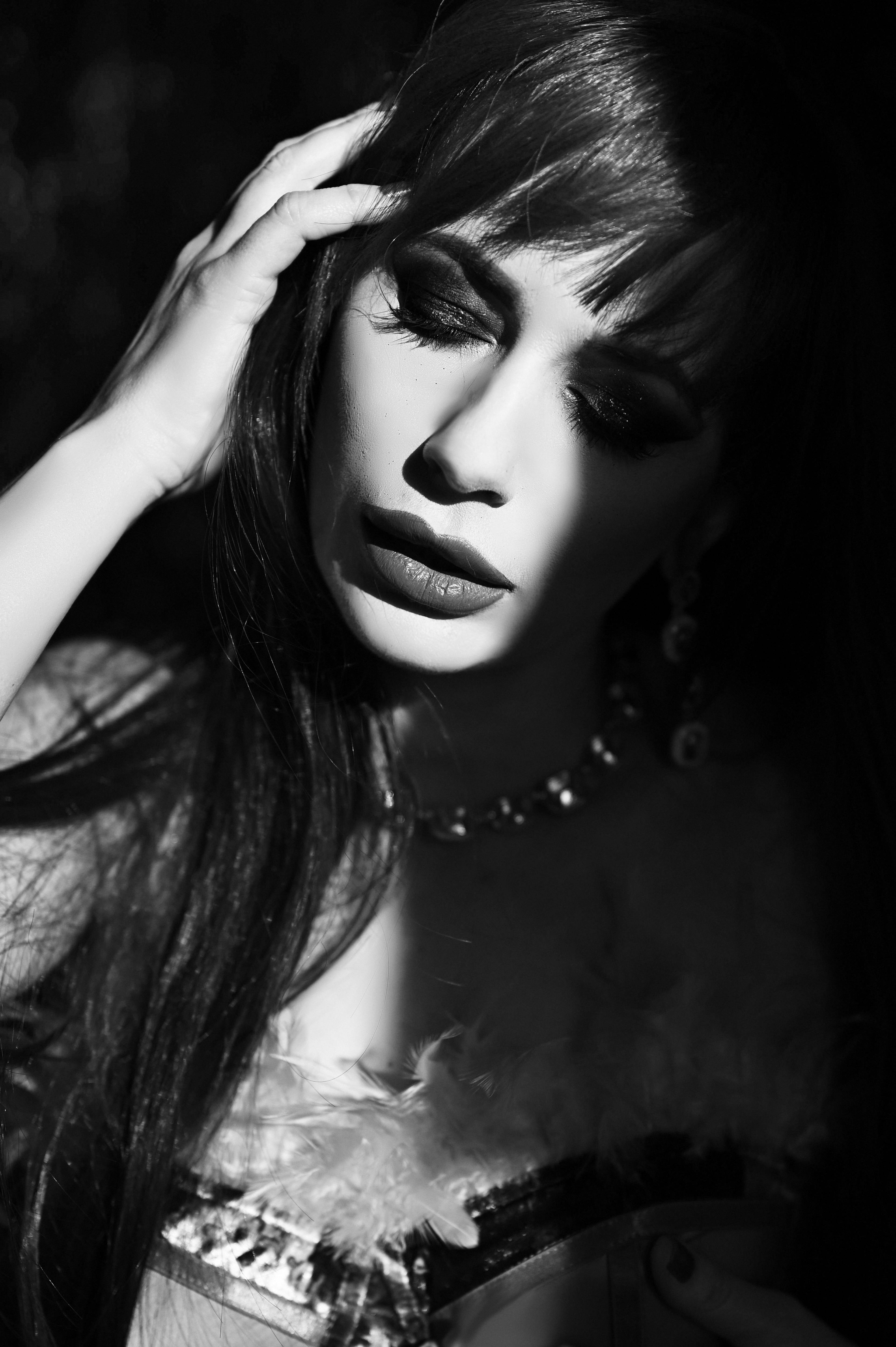 Gratis Foto artistica in bianco e nero che mette in risalto le ombre drammatiche sul volto di una donna. Foto a disposizione