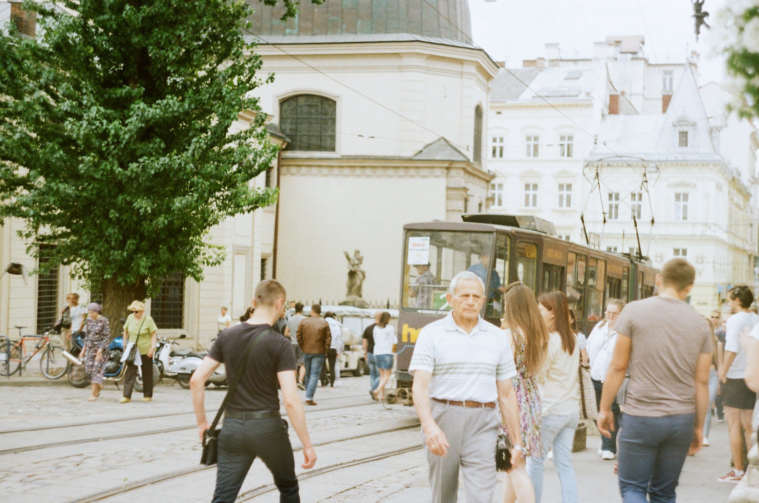 colorful historic buildings and cobblestone street in Lviv's Market Square with a tram passing by