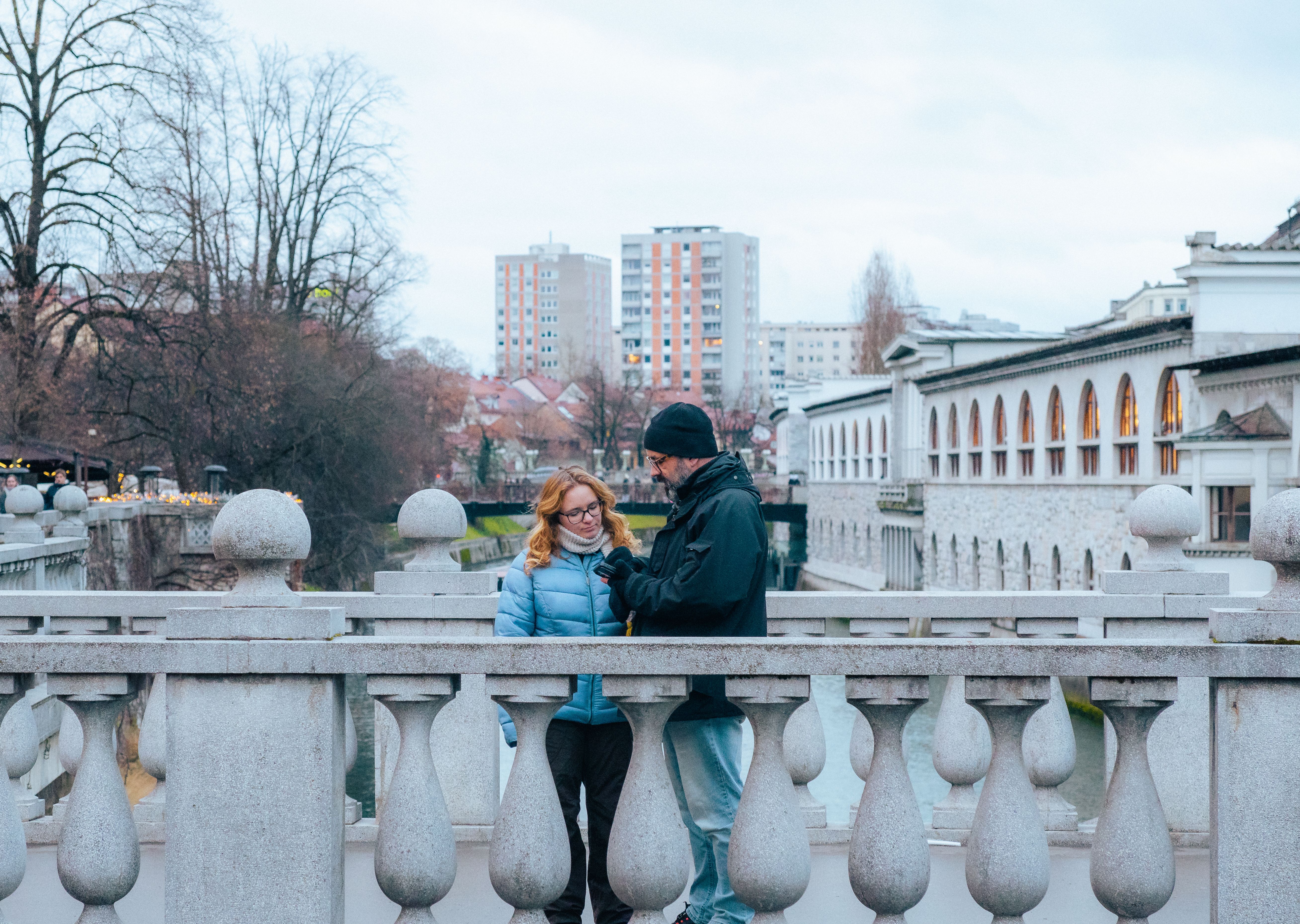 A couple converses on a bridge during a winter day in Ljubljana, Slovenia.
