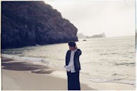 Young Adult Strolling on Serene Beach at Daybreak