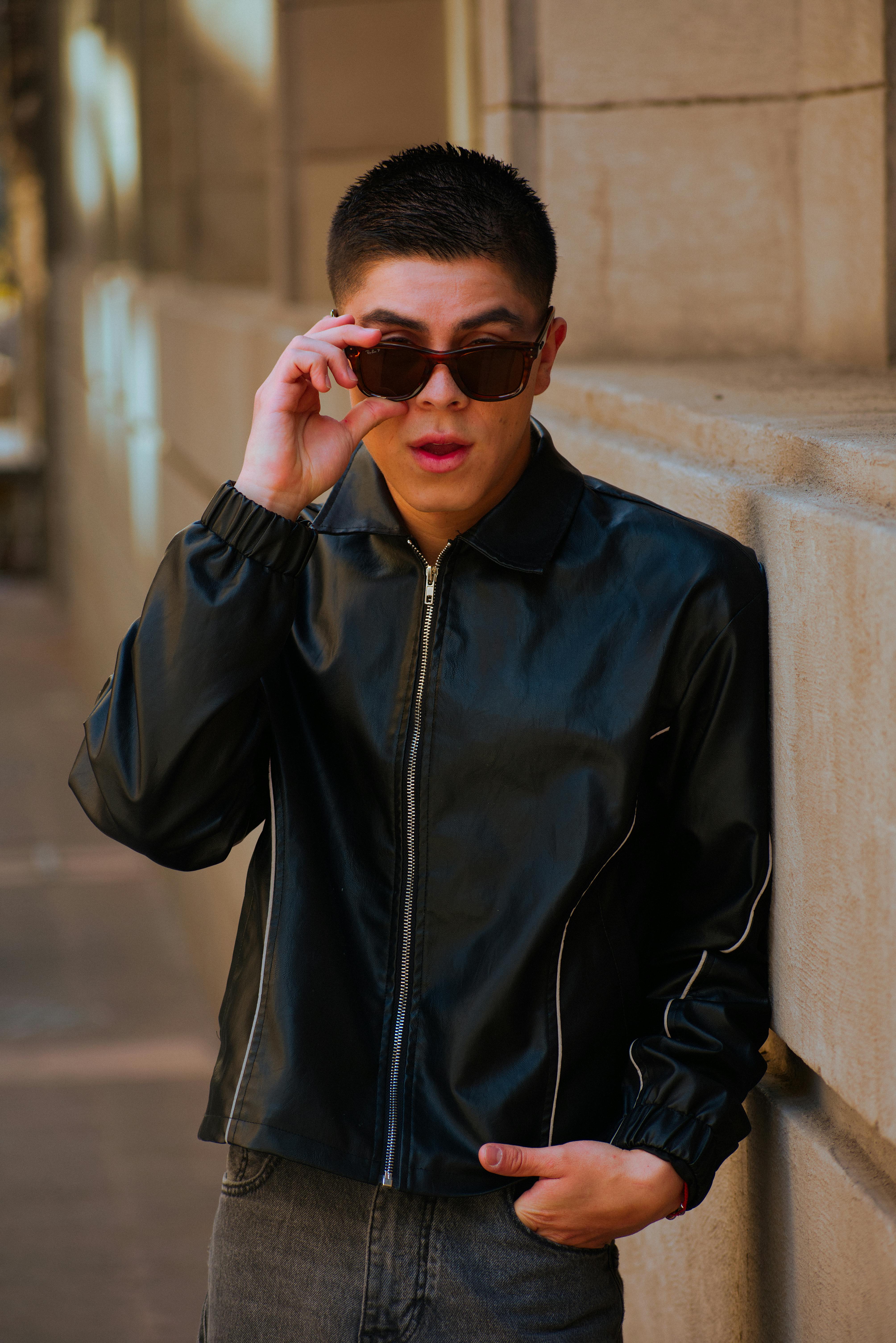 Gratis Un uomo elegante con una giacca di pelle posa con sicurezza in via Ciudad de México. Foto a disposizione