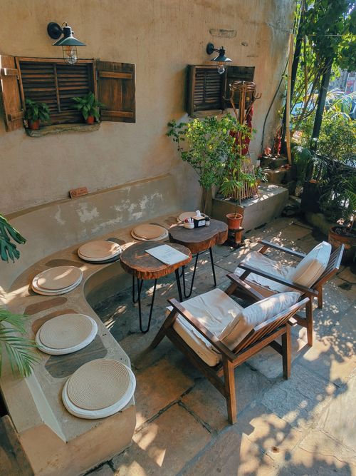 Free Inviting outdoor patio setting with rustic wooden furniture and lush greenery, perfect for relaxation. Stock Photo