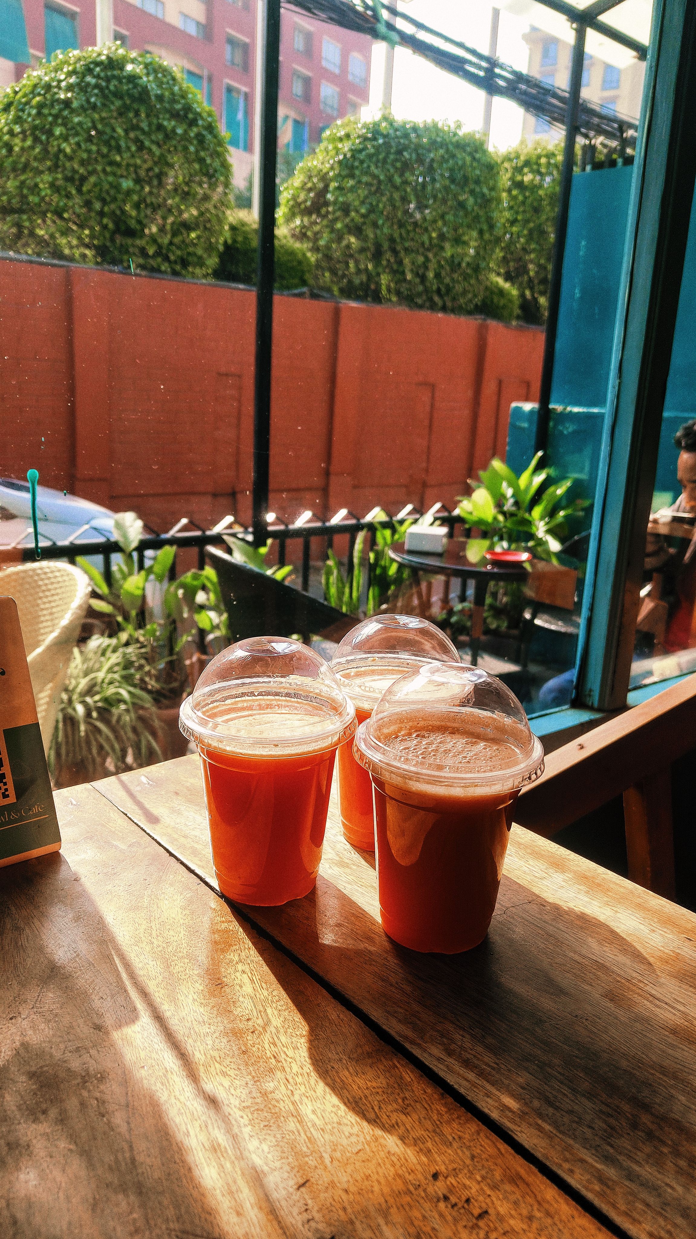 Refreshing view of fresh juice in sunlight at a cozy outdoor cafe.