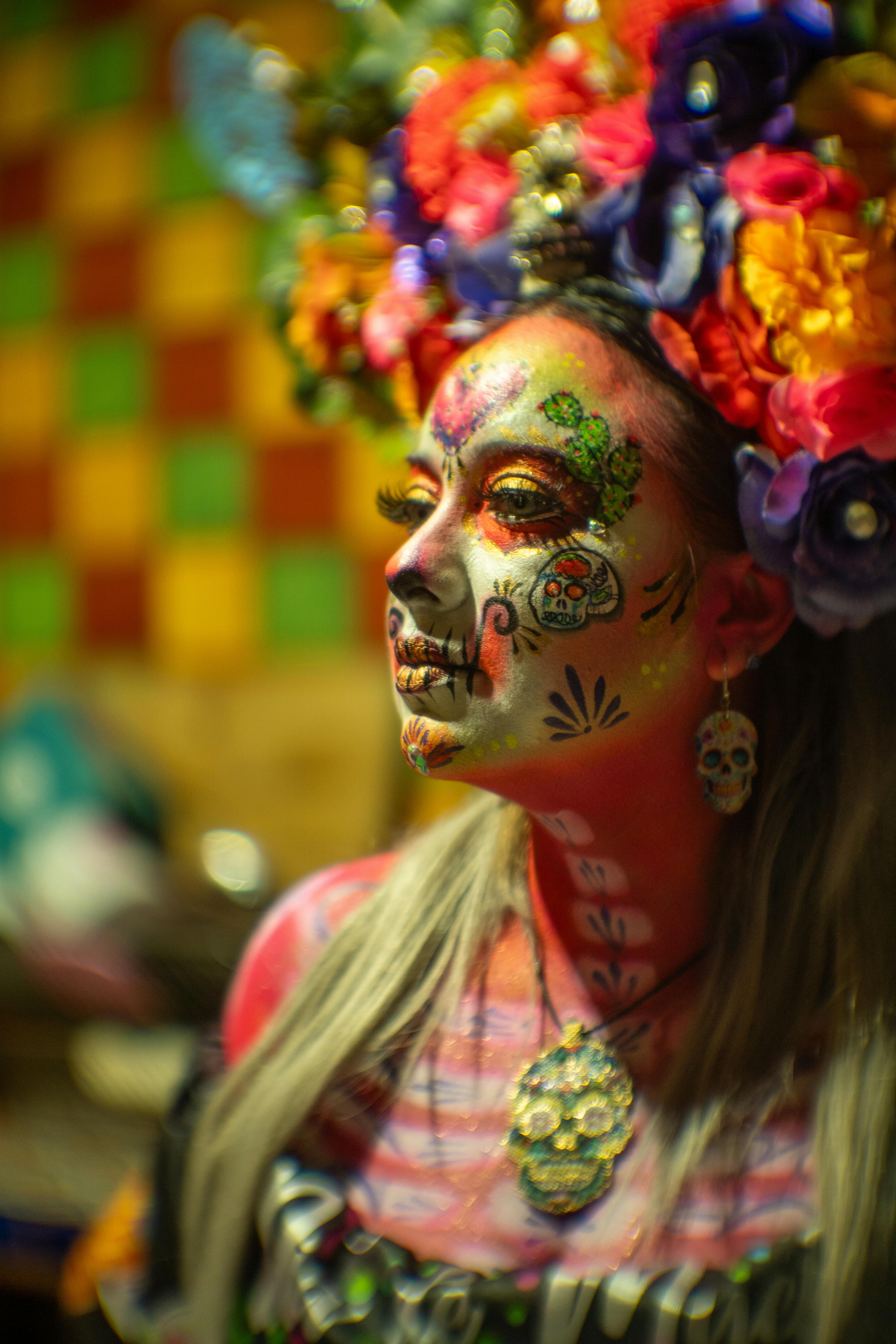 Gratis Seorang wanita dengan riasan Catrina berwarna-warni dan hiasan kepala bunga yang rumit, mewujudkan budaya Meksiko. Foto Stok