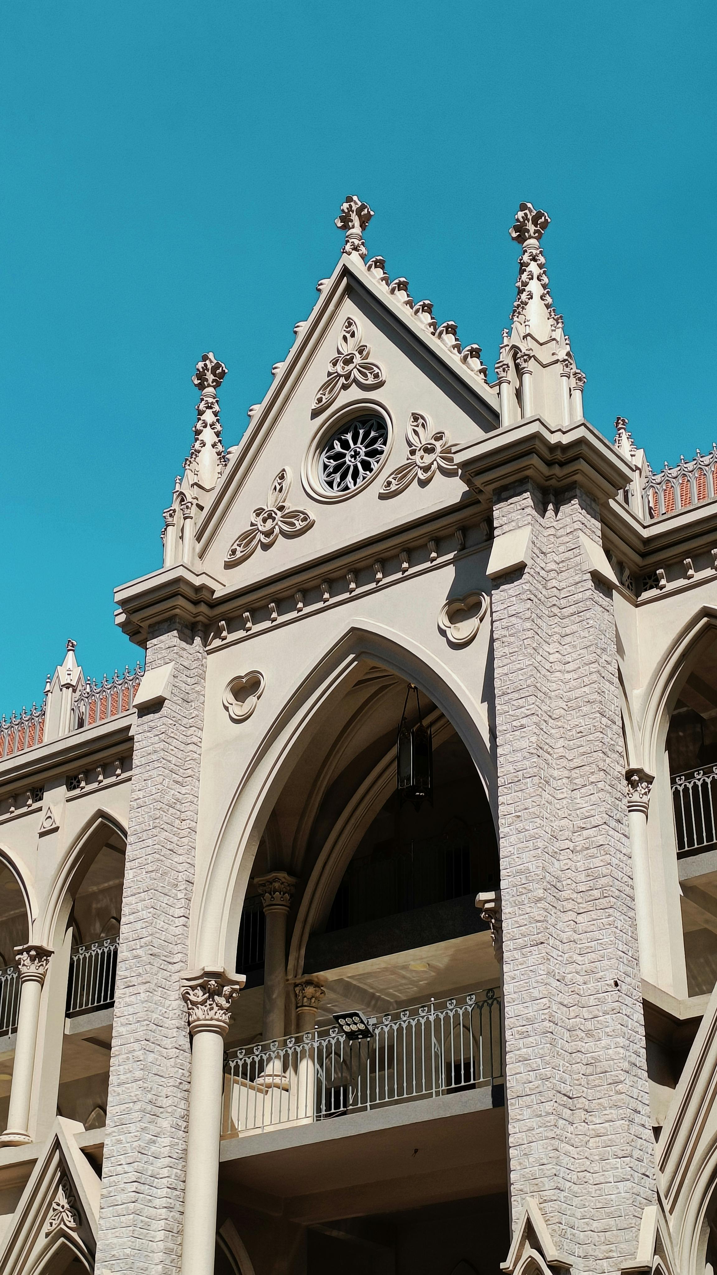 Gratis Arsitektur kebangkitan Gotik yang menakjubkan dengan detail rumit di bawah langit biru yang jernih. Foto Stok