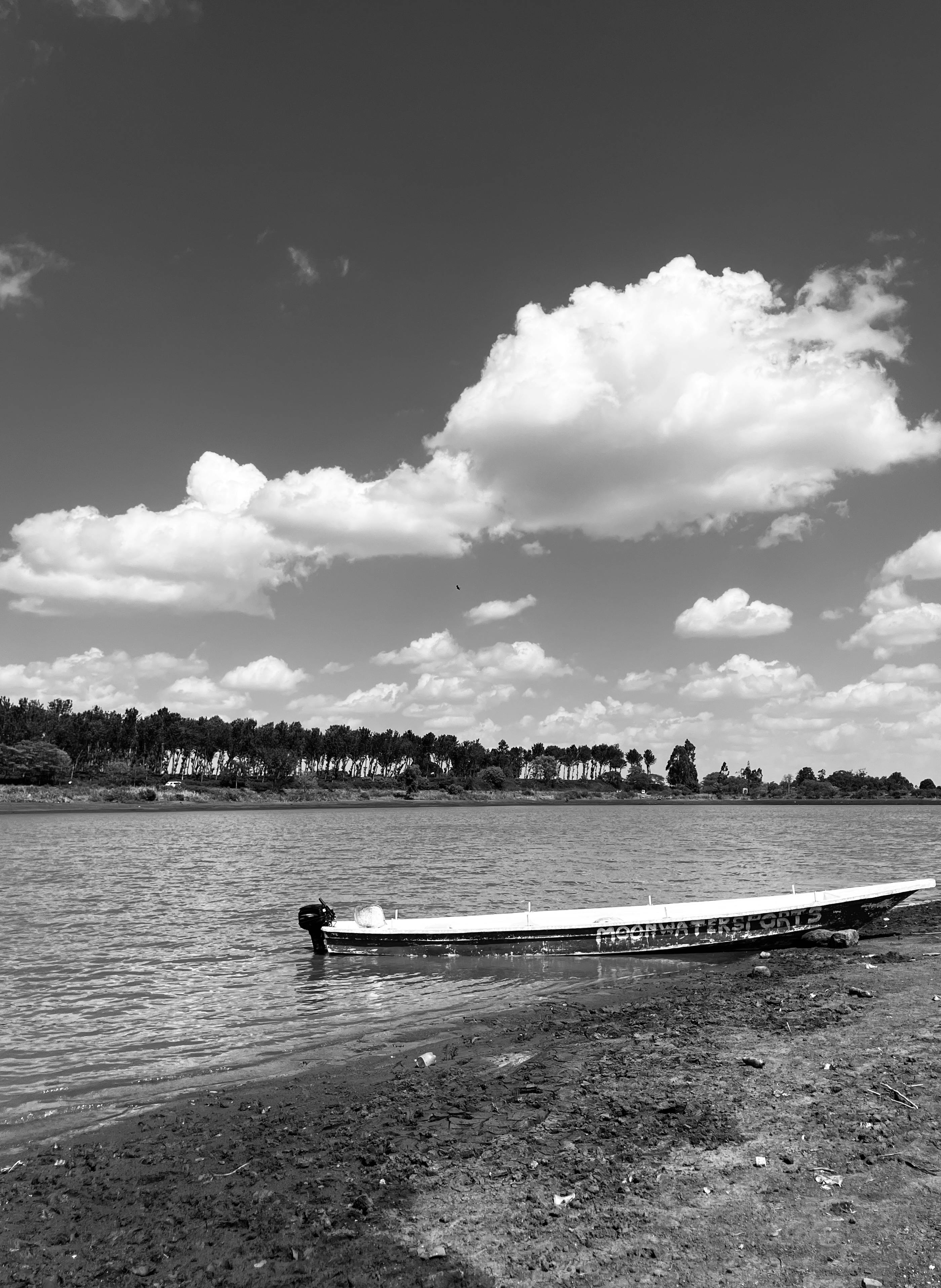 Безкоштовне Спокійна сцена човна на березі річки під хмарним небом у Руїру, Кенія. стокове фото