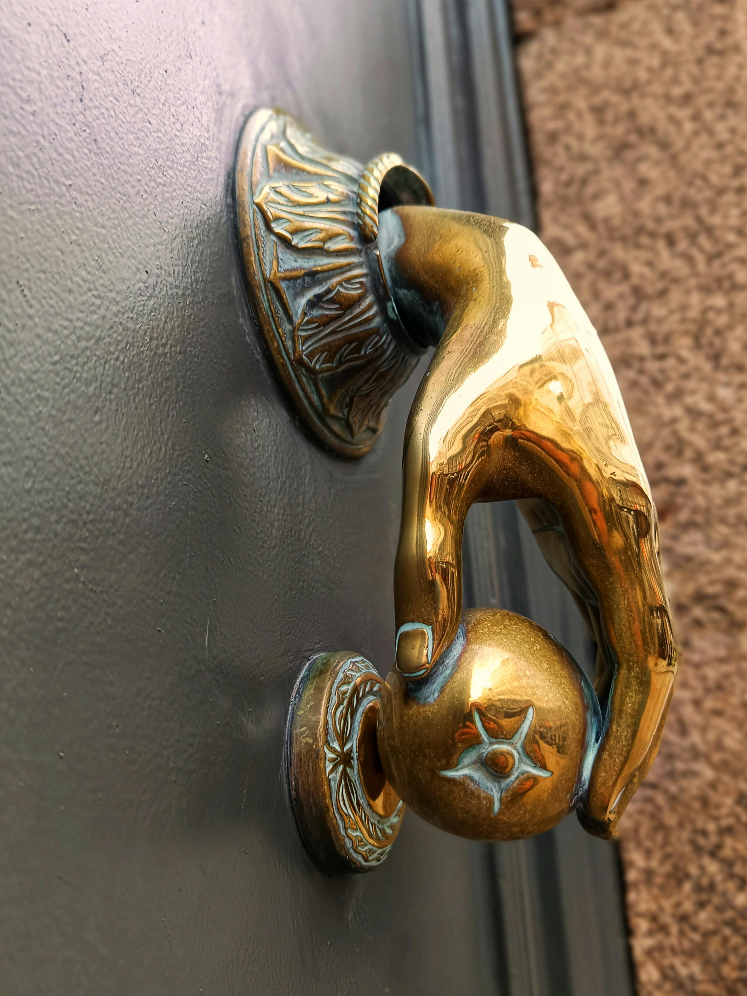 gratis Een gedetailleerde close-up van een messing deurklopper in de vorm van een hand die een bal vasthoudt, met een sierlijk ontwerp. Stockfoto