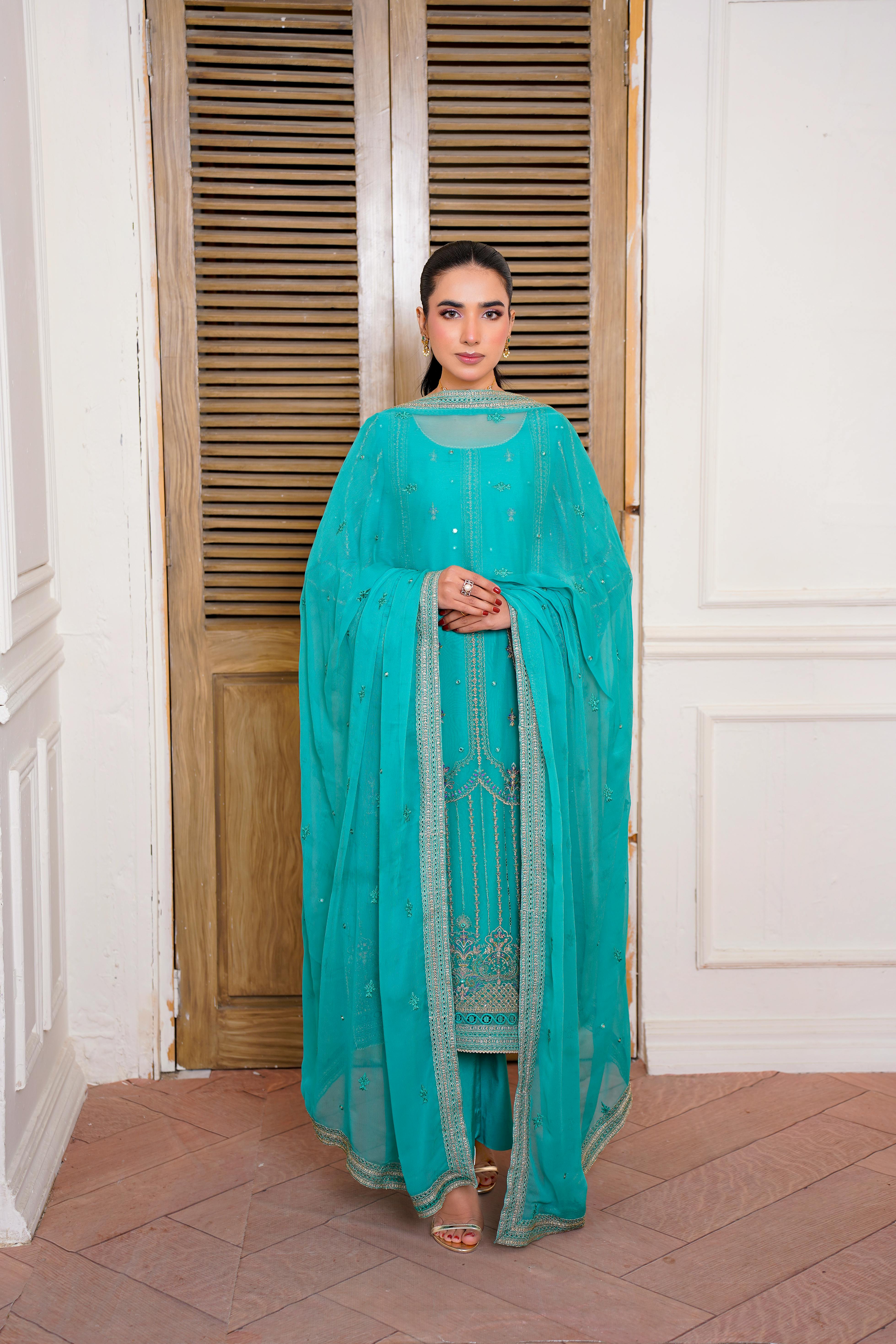 Free Model in turquoise embroidered Eastern dress indoors, showcasing elegant fashion in Lahore. Stock Photo