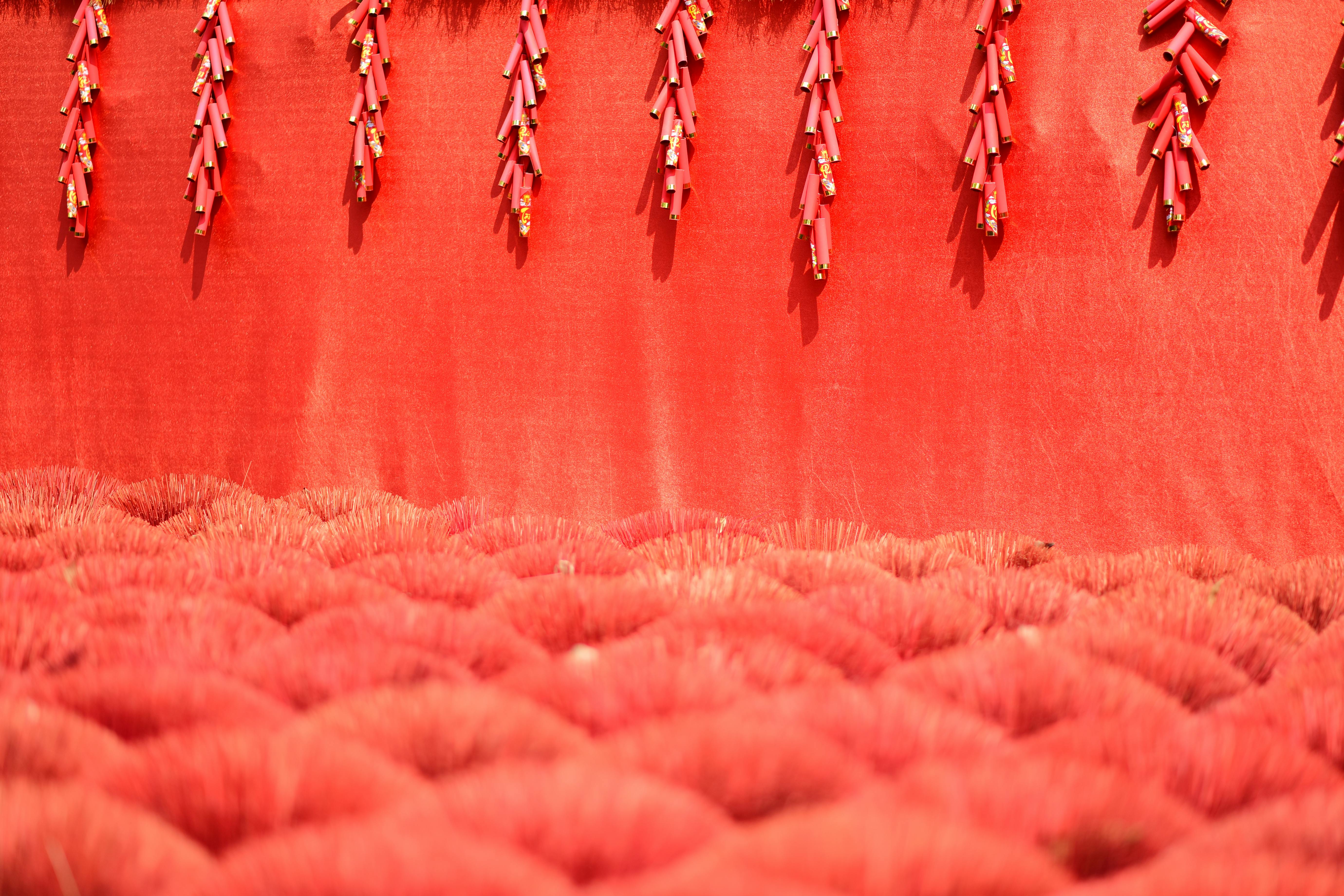 Abundant red incense sticks and firecrackers create a festive and vibrant scene.