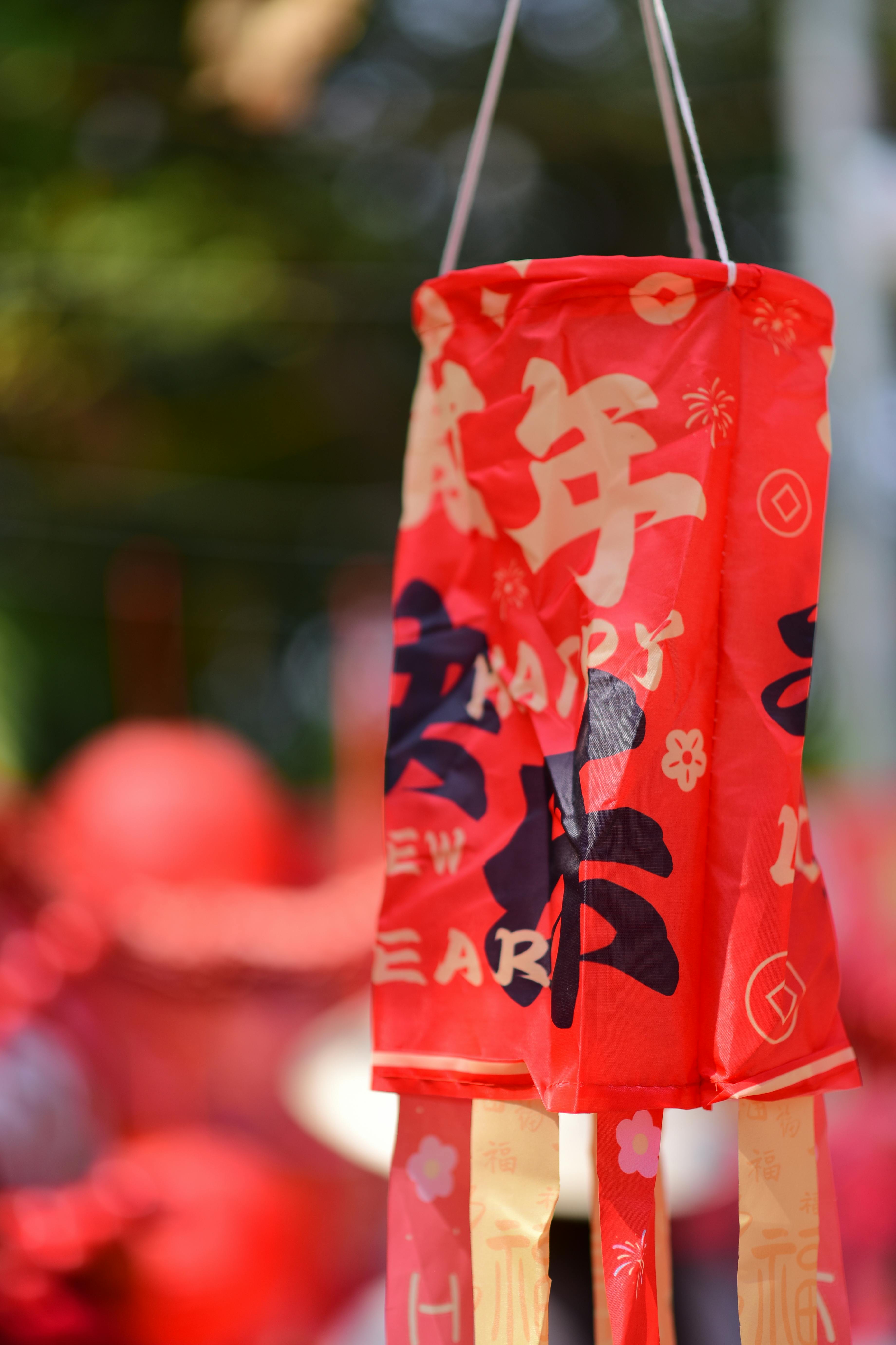 Red lantern with festive decorations for a Chinese New Year celebration outdoors.