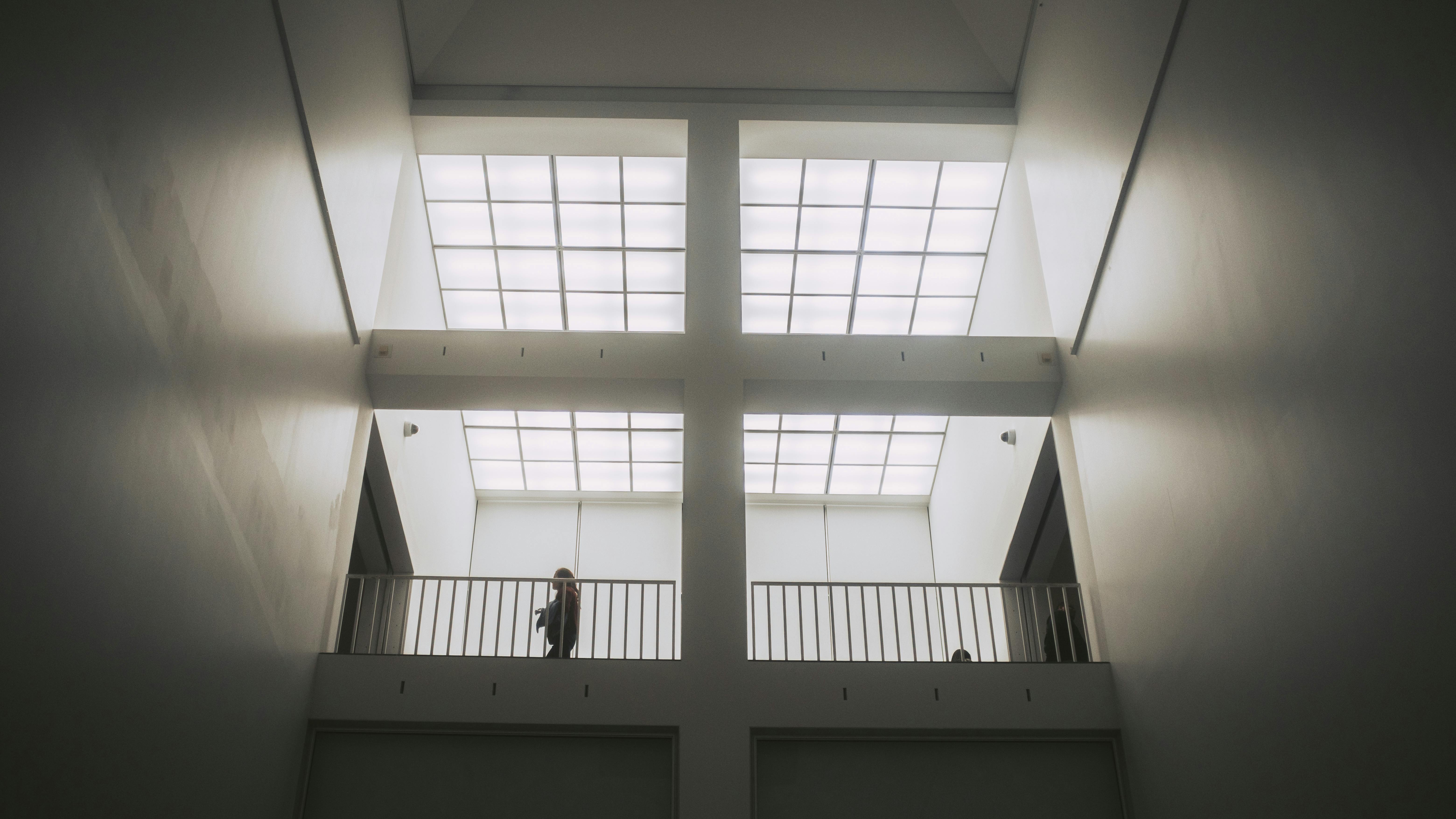 Gratis Vista interior del espacio arquitectónico moderno con persona recortada en el balcón. Foto de stock