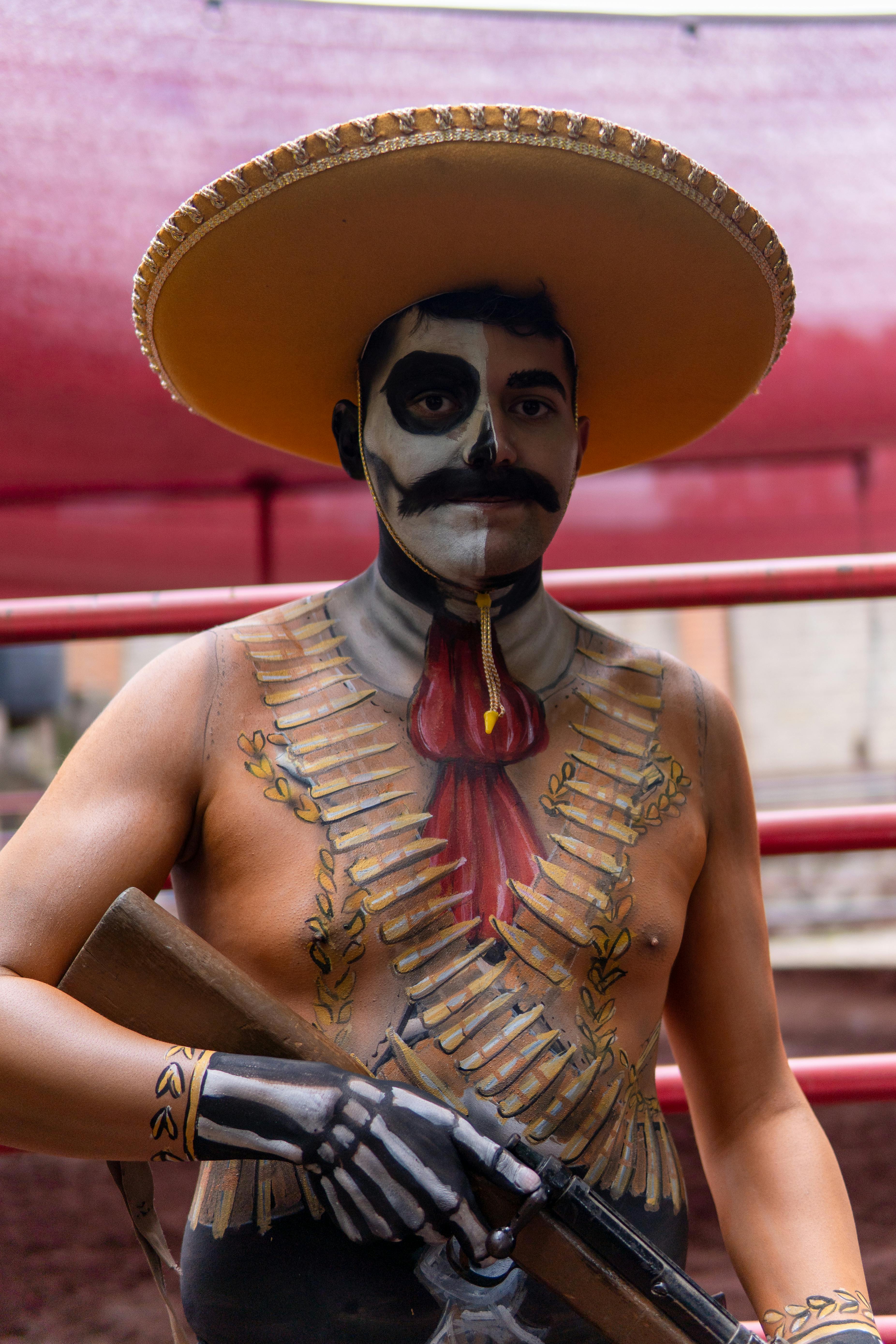 Gratis Potret seorang pria dengan riasan dan kostum Catrina yang rumit, memegang senjata tiruan di Kota Meksiko. Foto Stok