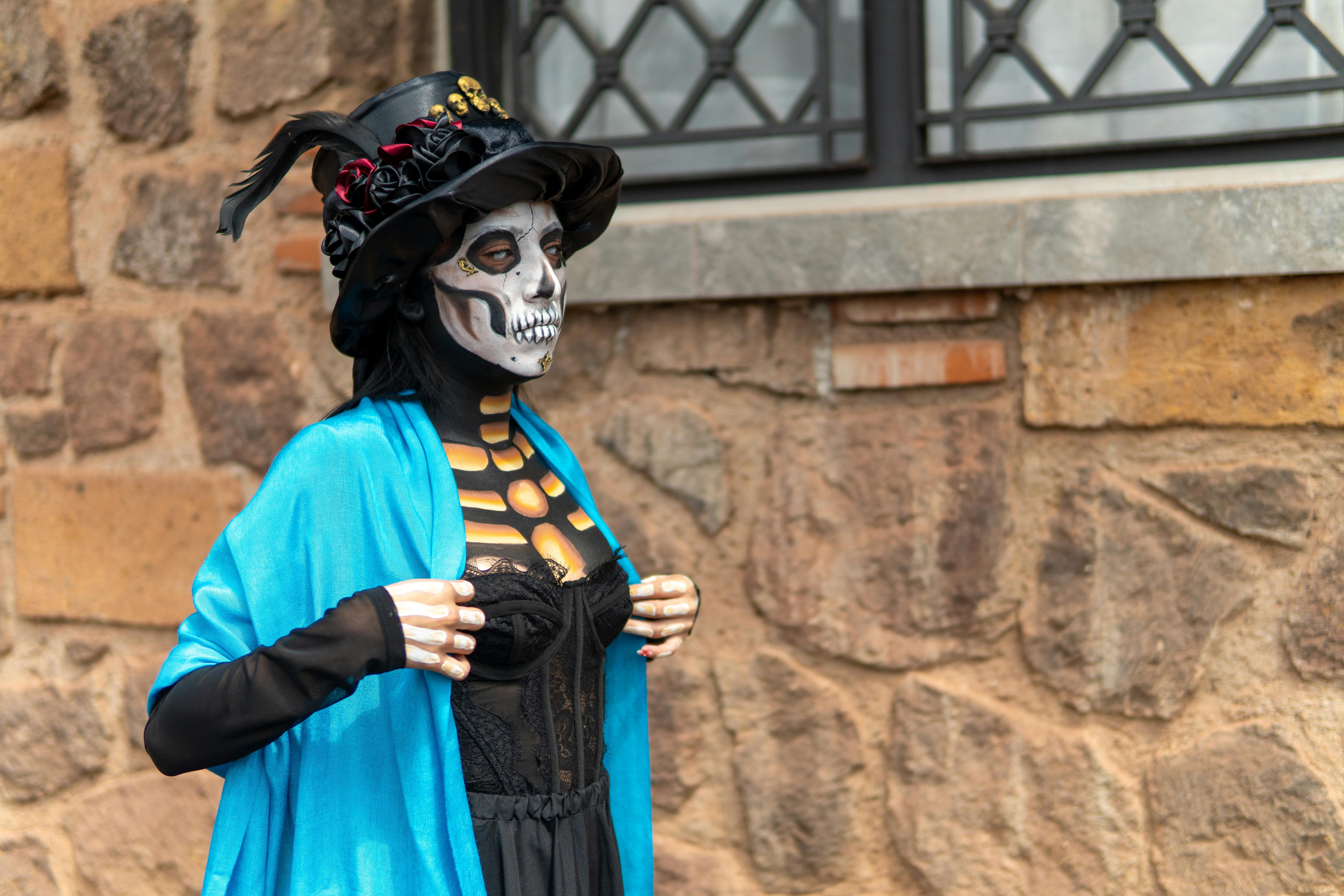 gratis Een vrouw met traditionele Catrina-make-up en -kleding toont in de buitenlucht Mexicaanse culturele kleding. Stockfoto