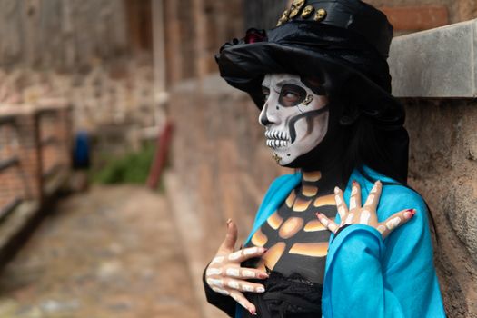 A person in Catrina makeup and costume poses outdoors in Mexico City, showcasing vibrant Mexican tradition.