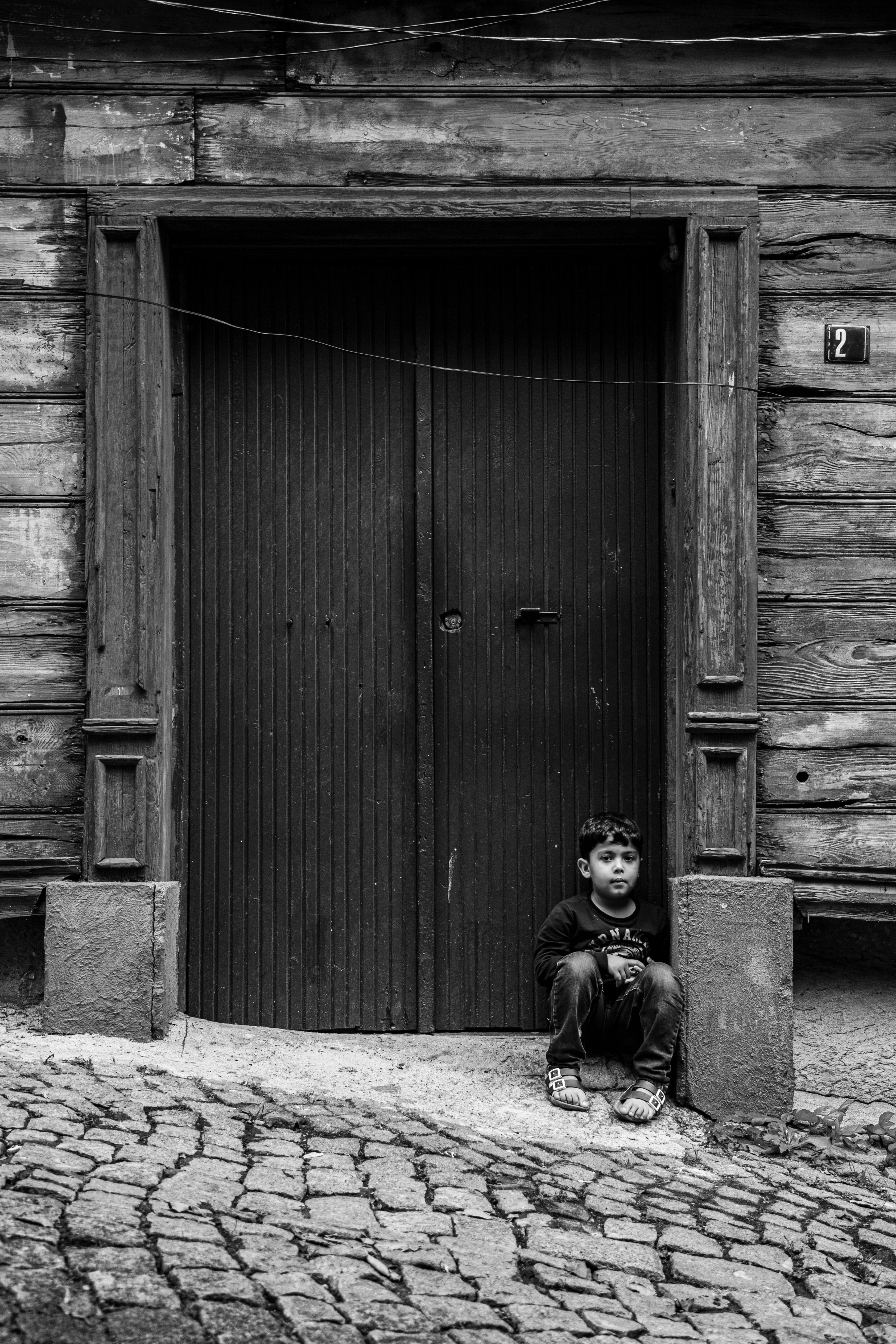 Безкоштовне Дитина сидить на бруківці в Стамбулі, демонструючи традиційну архітектуру. стокове фото