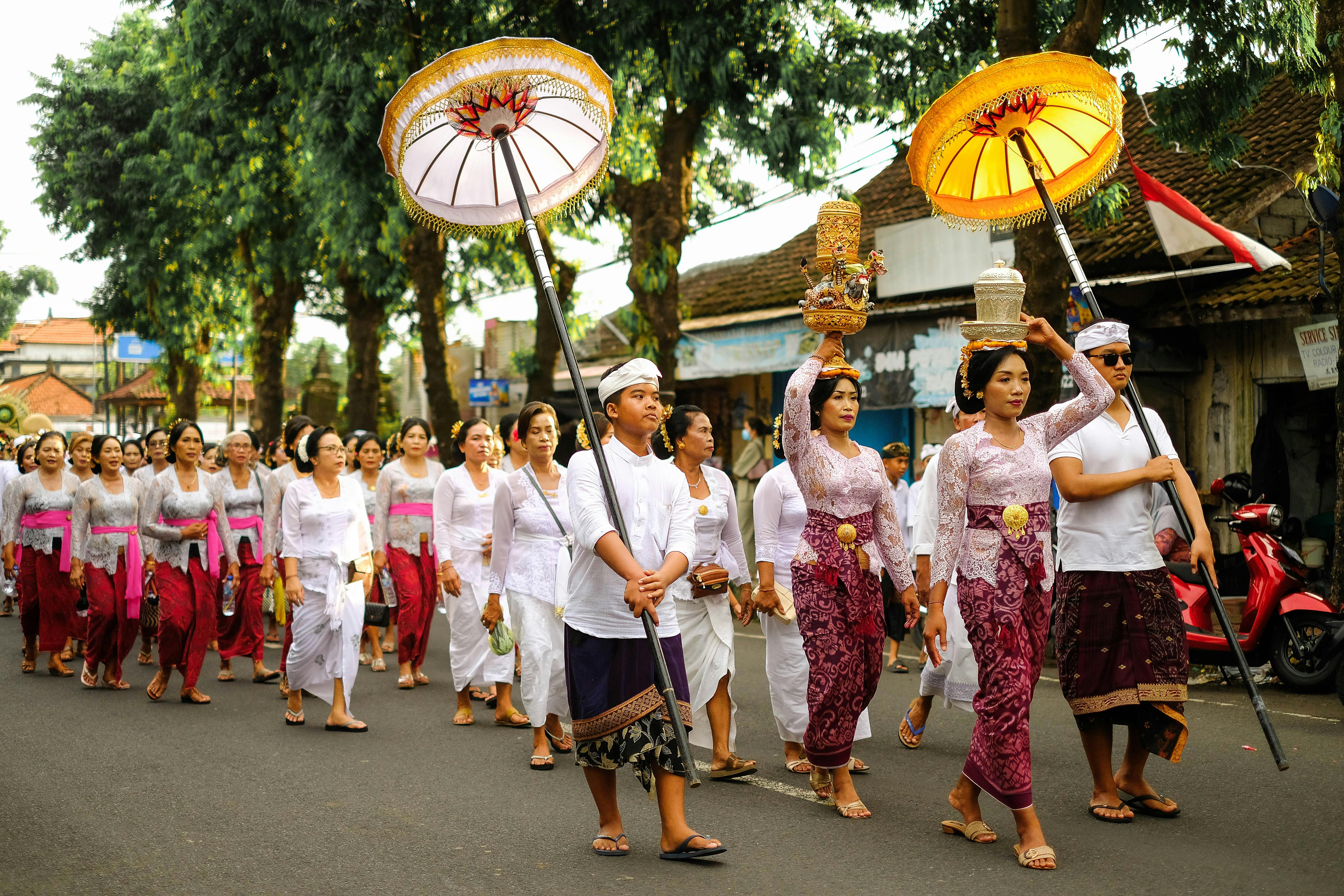 A vibrant Balinese cultural parade with participants in traditional attire, showcasing local heritage.
