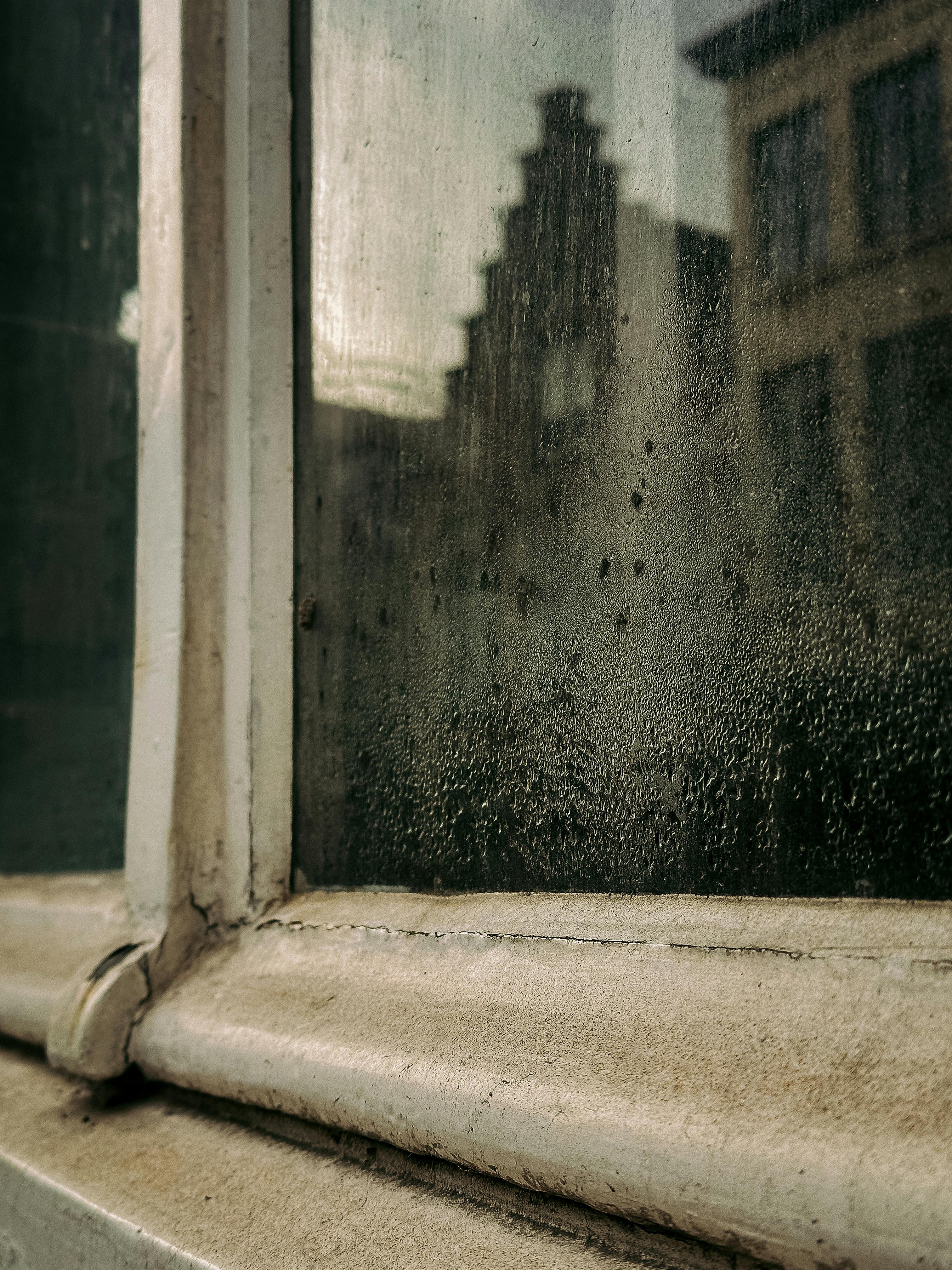 Gratis Una vista melancólica de la arquitectura flamenca a través de una ventana empañada en Brujas, Bélgica. Foto de stock