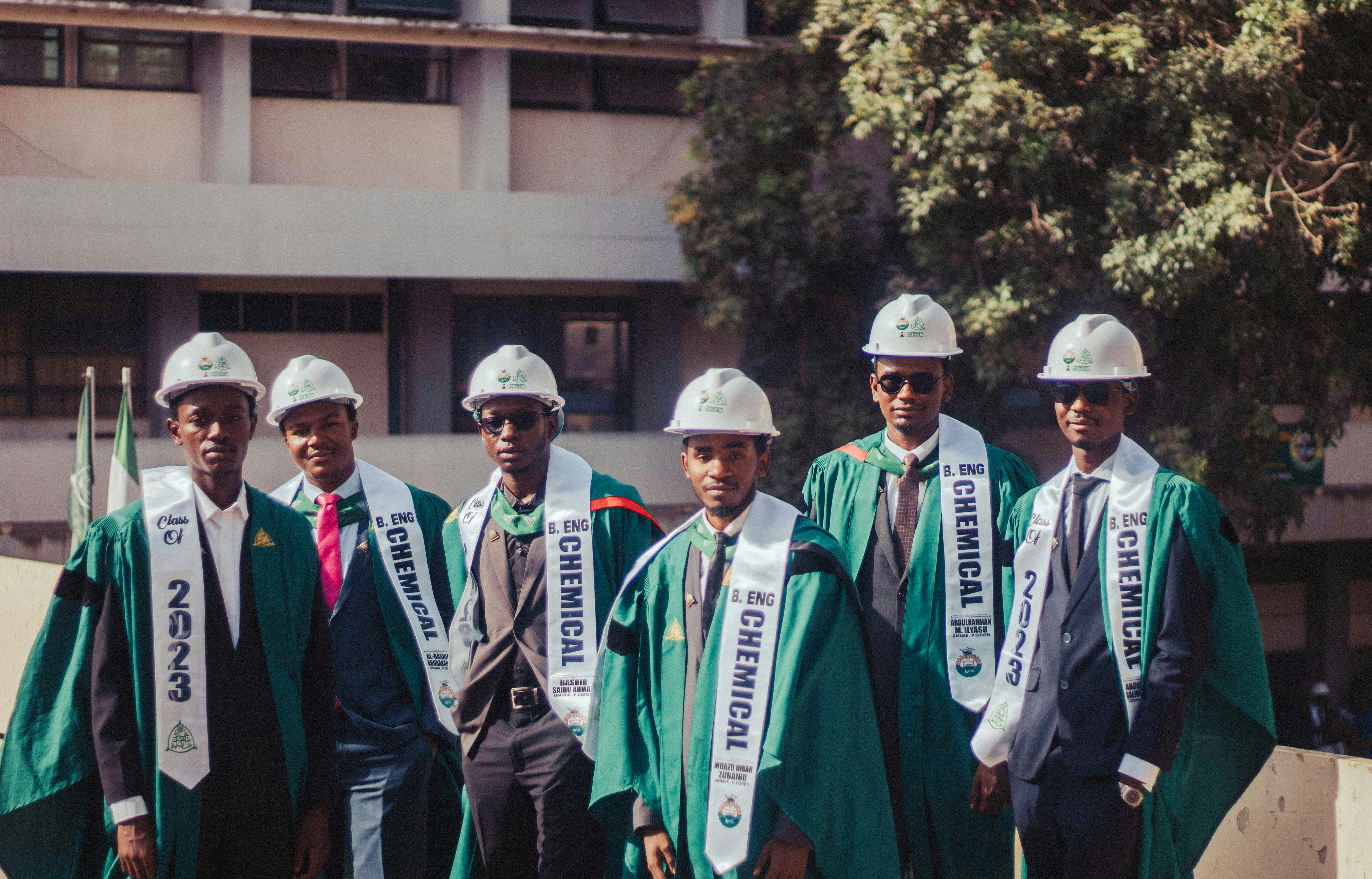 Δωρεάν Ομάδα αποφοίτων χημικής μηχανικής που φορούν ακαδημαϊκές στολές και κράνη σε εξωτερικούς χώρους. Φωτογραφία από στοκ φωτογραφιών