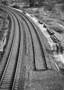 Black and White Railway Tracks Curving Outdoors