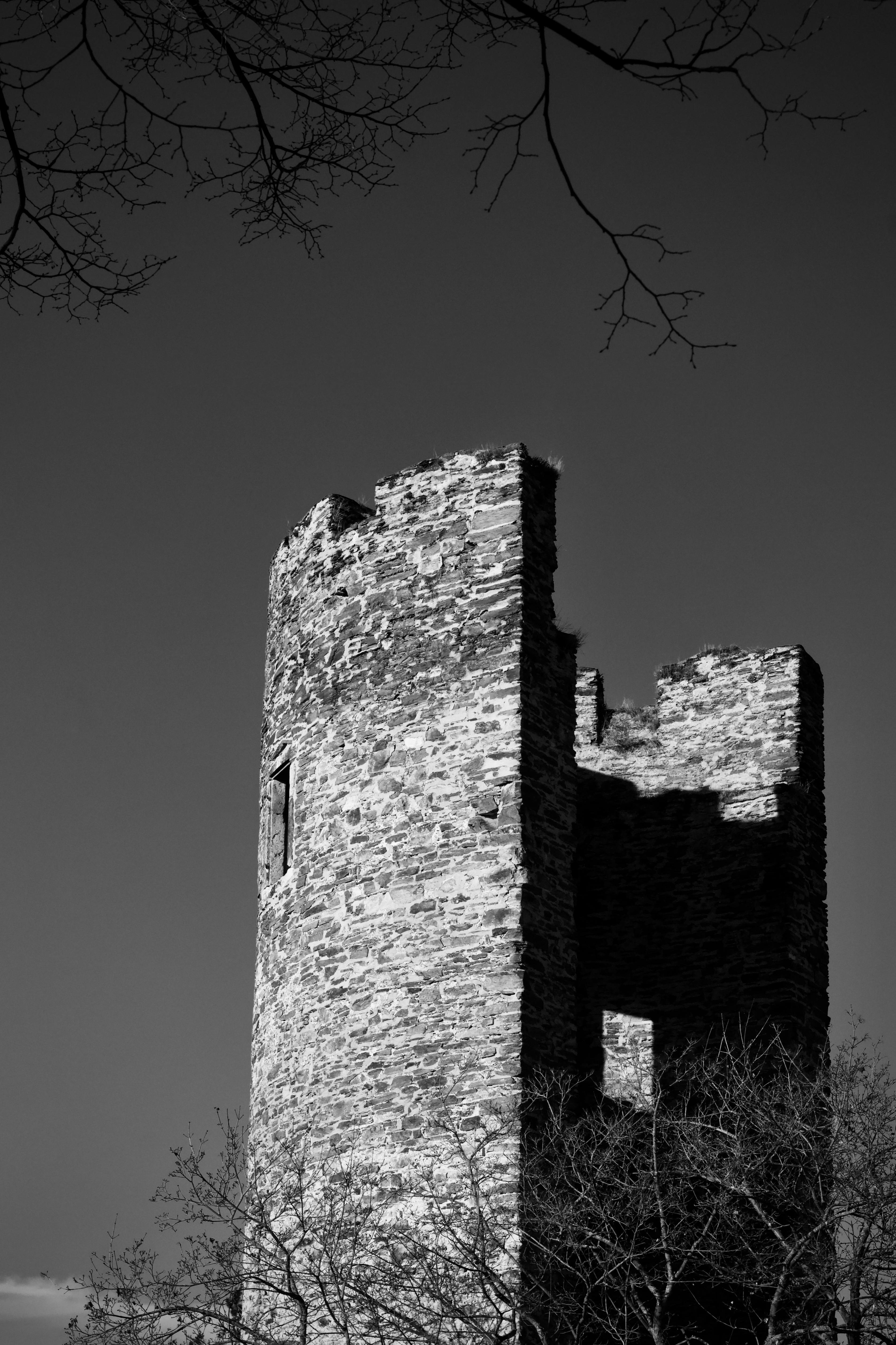 common:alt.prefix Fotografia em preto e branco de uma antiga torre de pedra sob um céu limpo. common:alt.postfix