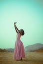 African Woman in Pink Dress Dancing Outdoors