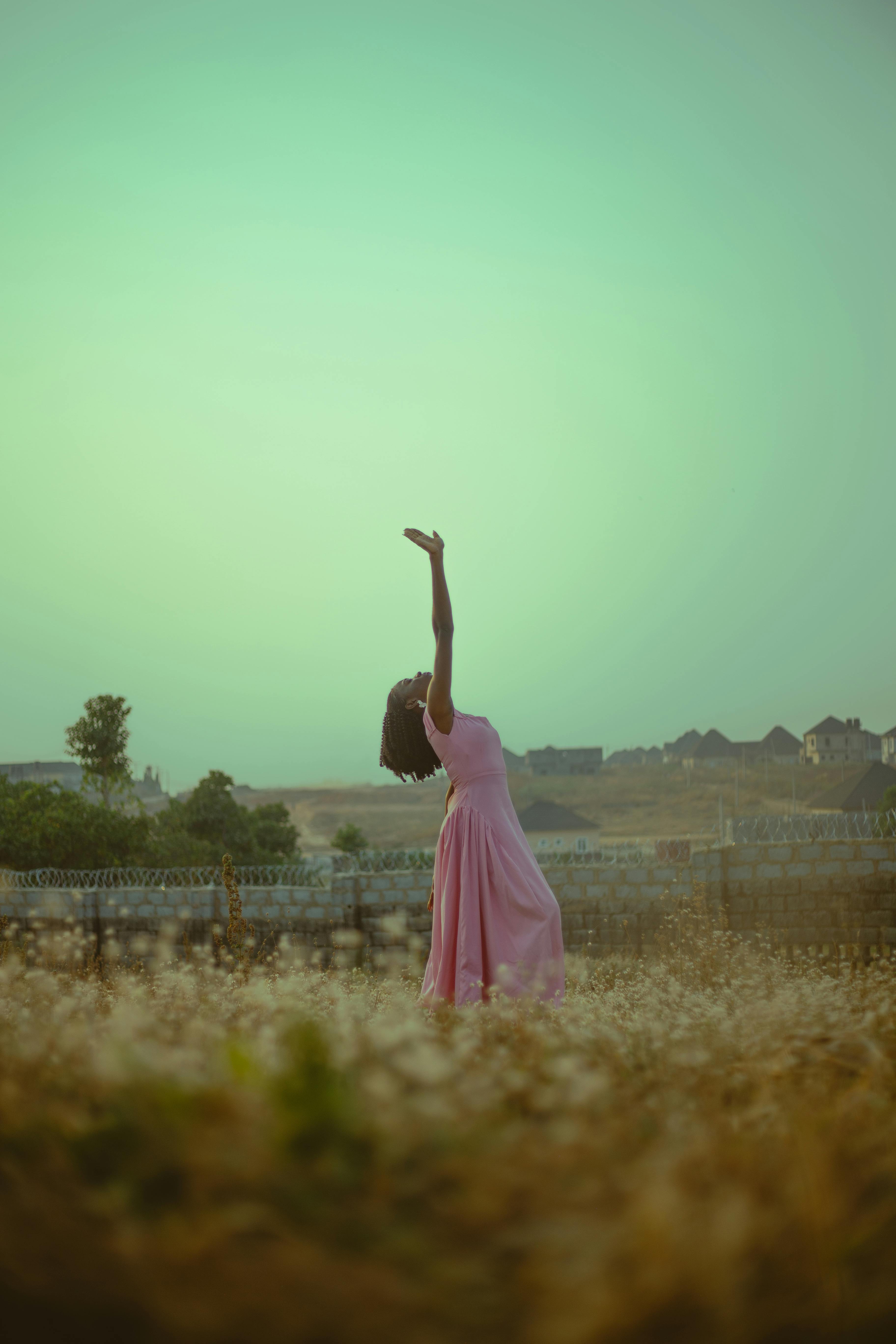 Miễn phí Một người phụ nữ mặc váy hồng tạo dáng duyên dáng trong khung cảnh ngoài trời tuyệt đẹp. Ảnh lưu trữ