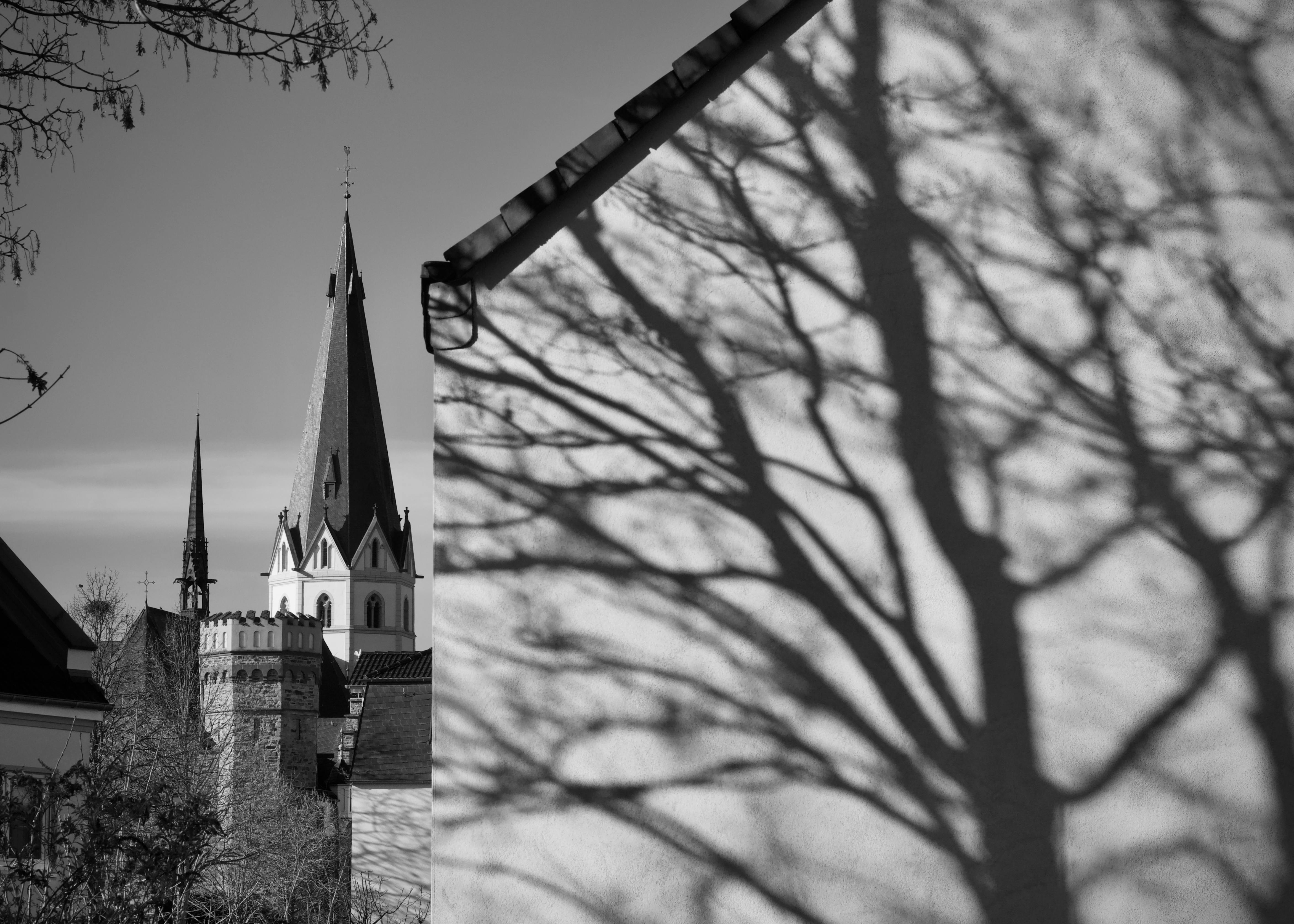 ingyenes Egy drámai fekete-fehér fotó, amelyen egy templomtorony látható, melynek falán bonyolult árnyékok húzódnak. Stockfotó