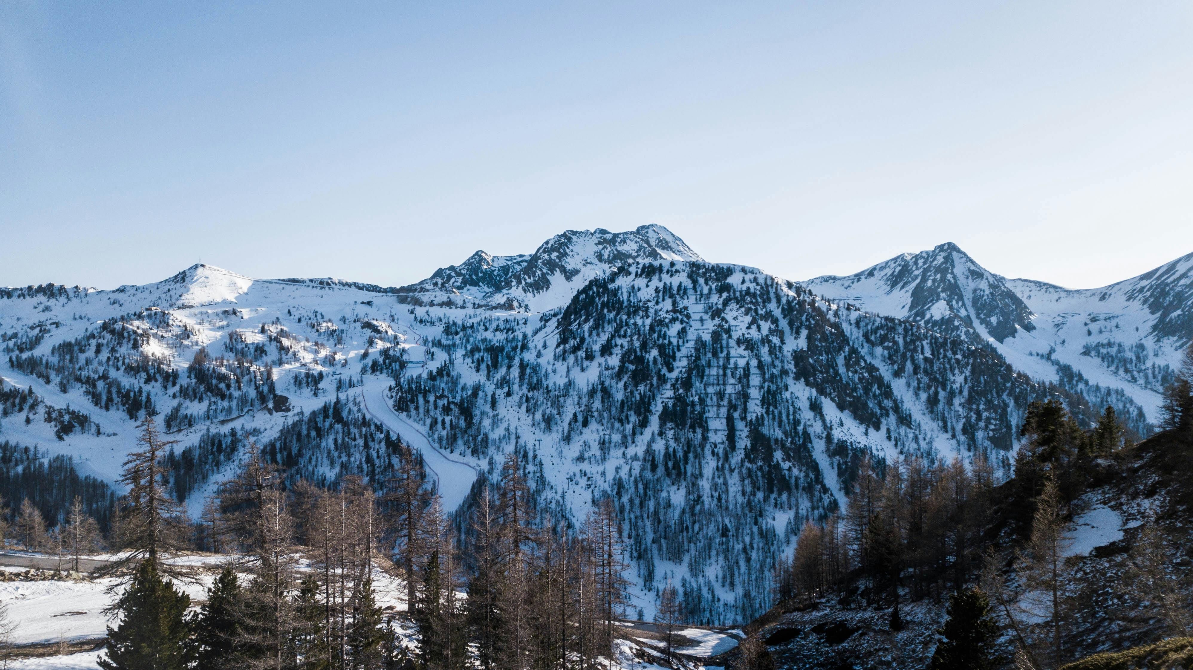 gratis Een adembenemend uitzicht op de met sneeuw bedekte Alpen, die de schoonheid van de winter laten zien. Stockfoto