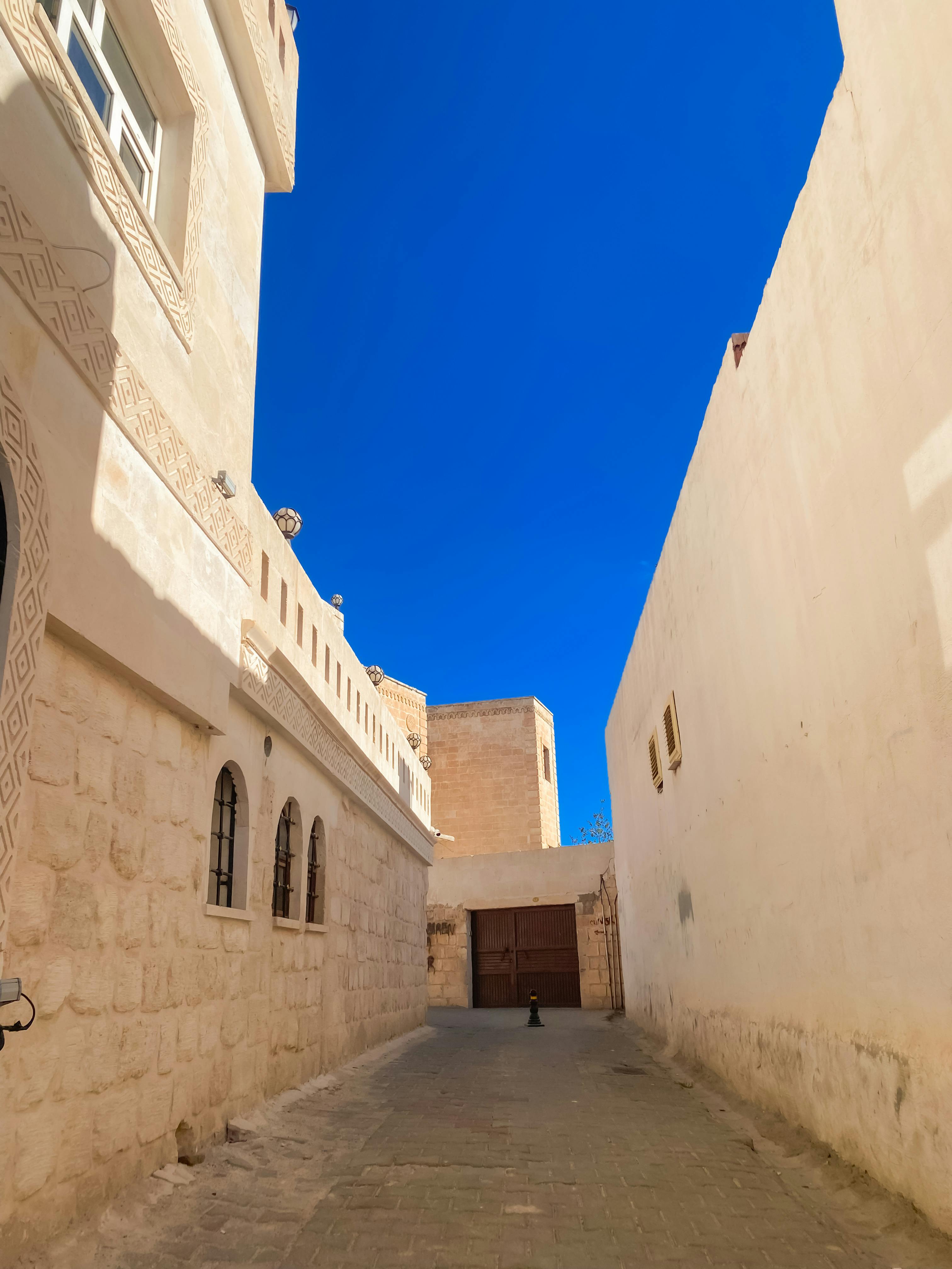 Gratuit Alee fermecătoare în Midyat, Mardin, cu arhitectură tradițională din piatră, sub un cer albastru vibrant. Fotografie de stoc