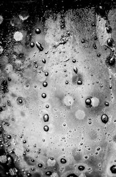 Abstract close-up of water droplets on glass in monochrome, creating a moody ambiance.