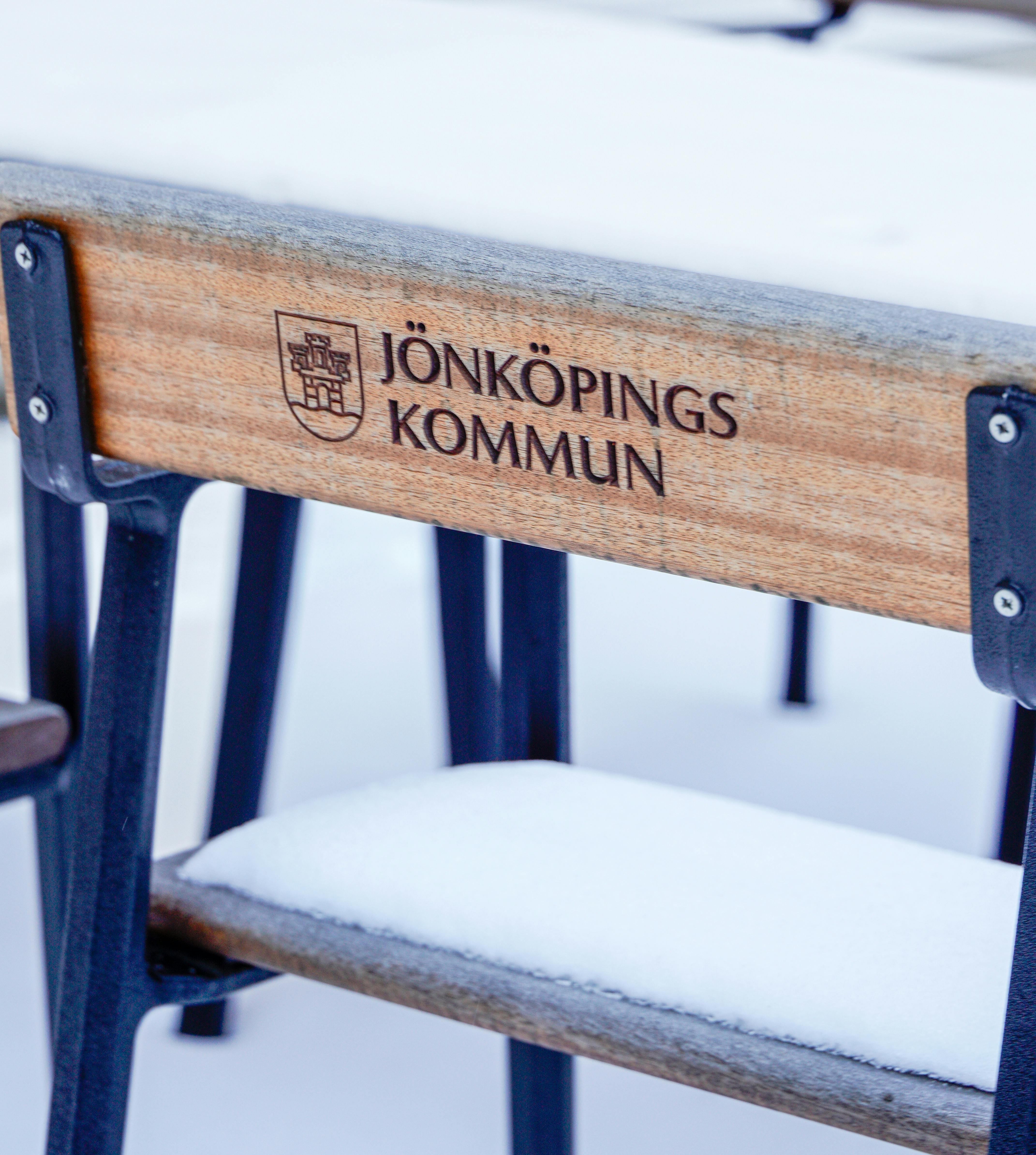 Winter scene featuring a snow-covered bench in Jönköping, Sweden.