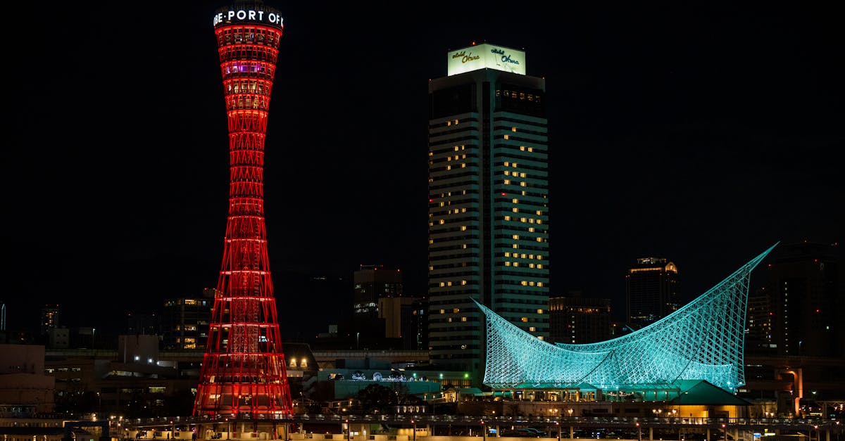 Stunning night view of Kobe Port Tower and Maritime Museum reflecting on water in Kobe, Japan.