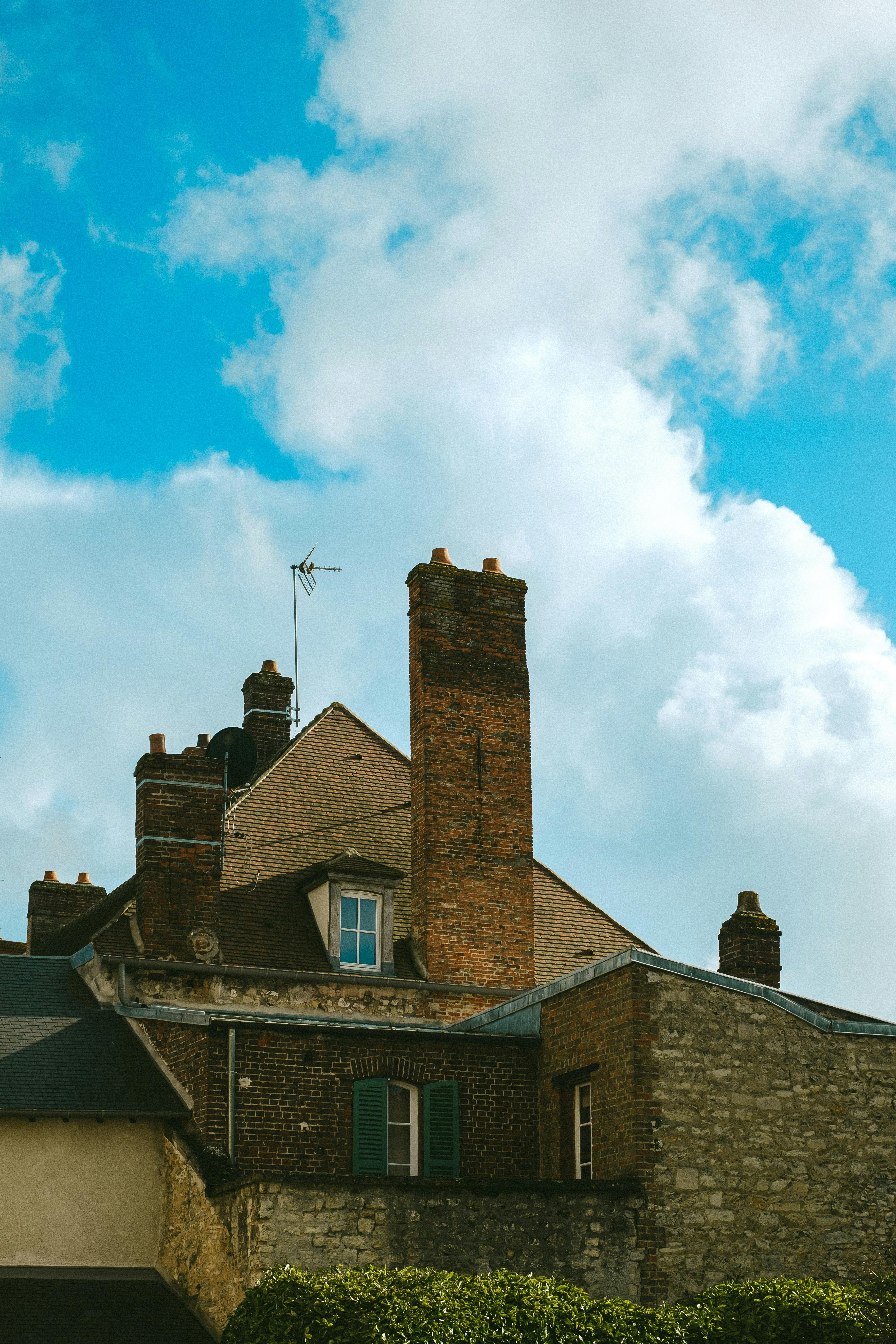 common:alt.prefix Vista de telhados rústicos de tijolos sob um céu azul brilhante, simbolizando a arquitetura europeia. common:alt.postfix