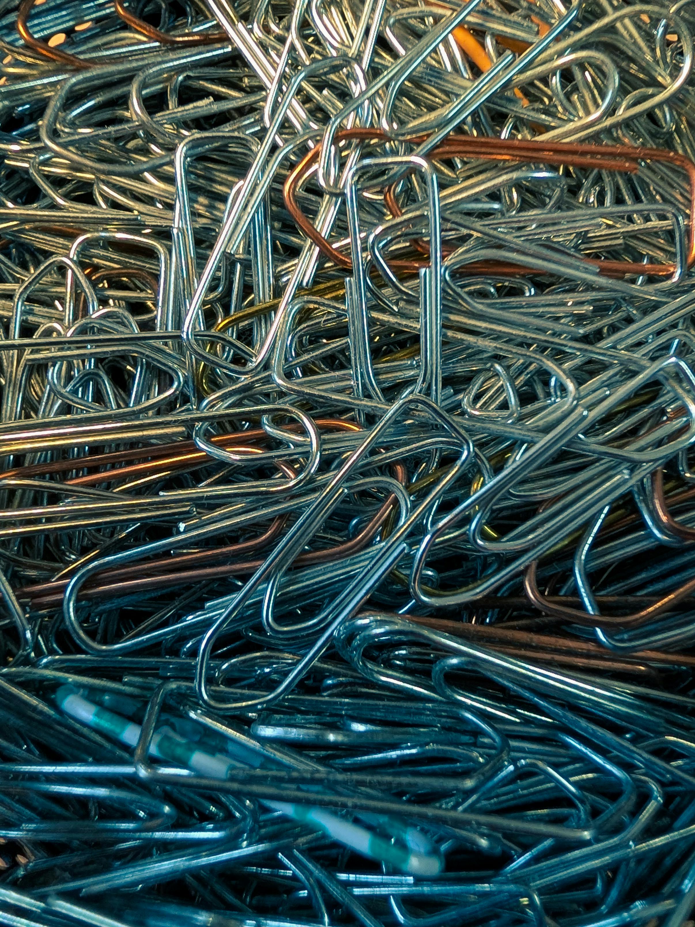 gratis Een stapel kleurrijke metalen paperclips van dichtbij, waarop hun texturen en kleuren goed te zien zijn. Stockfoto