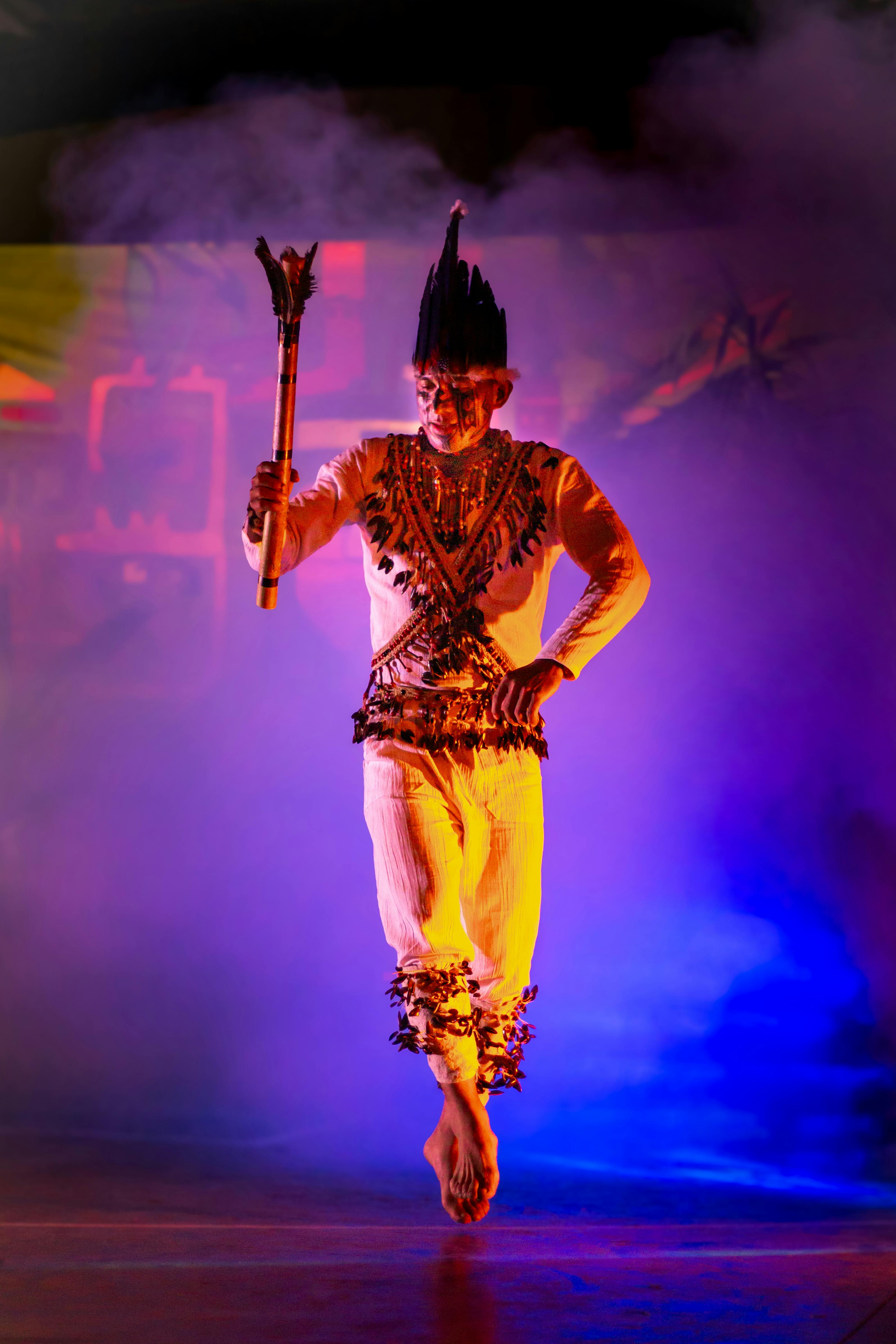 Miễn phí Một nghệ sĩ trong trang phục truyền thống đang múa uyển chuyển trên nền phông màu sắc rực rỡ. Ảnh lưu trữ