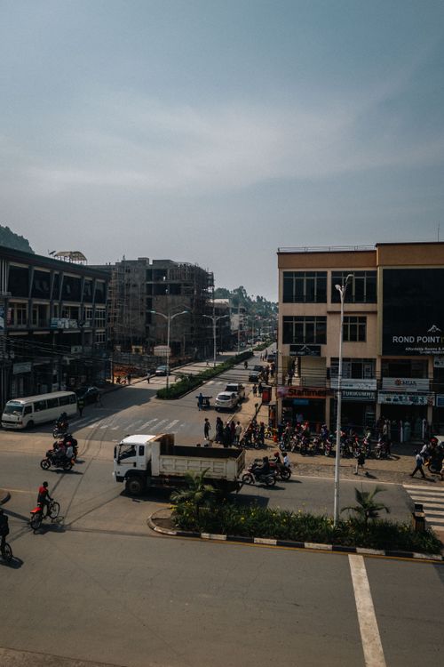Free Street view of a bustling intersection in an urban African city with motorbikes and vehicles. Stock Photo