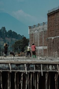 Construction workers on site building with scenic background.
