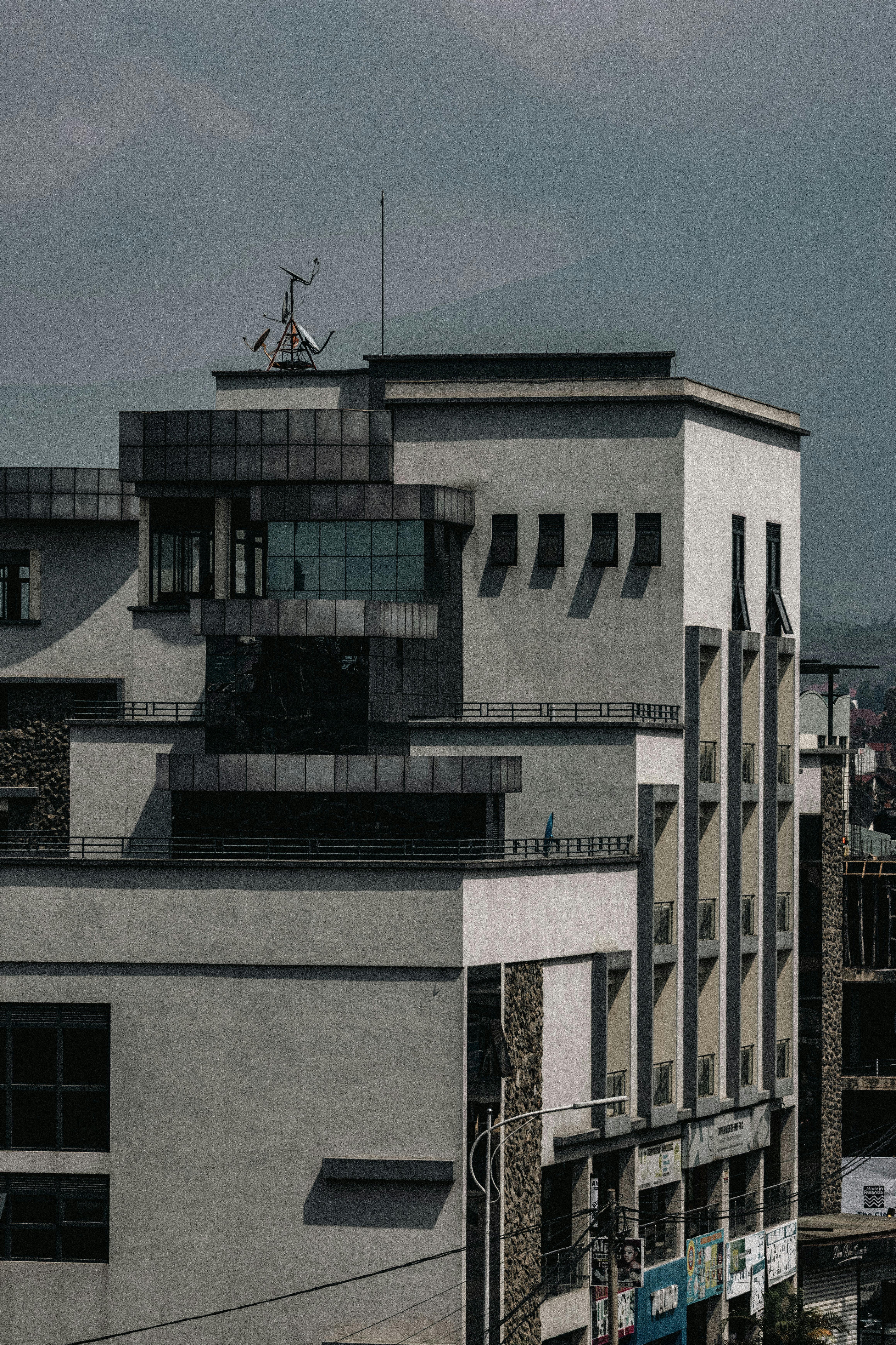 Gratis Un moderno edificio a più piani dal design geometrico sotto un cielo nuvoloso in una zona urbana. Foto a disposizione