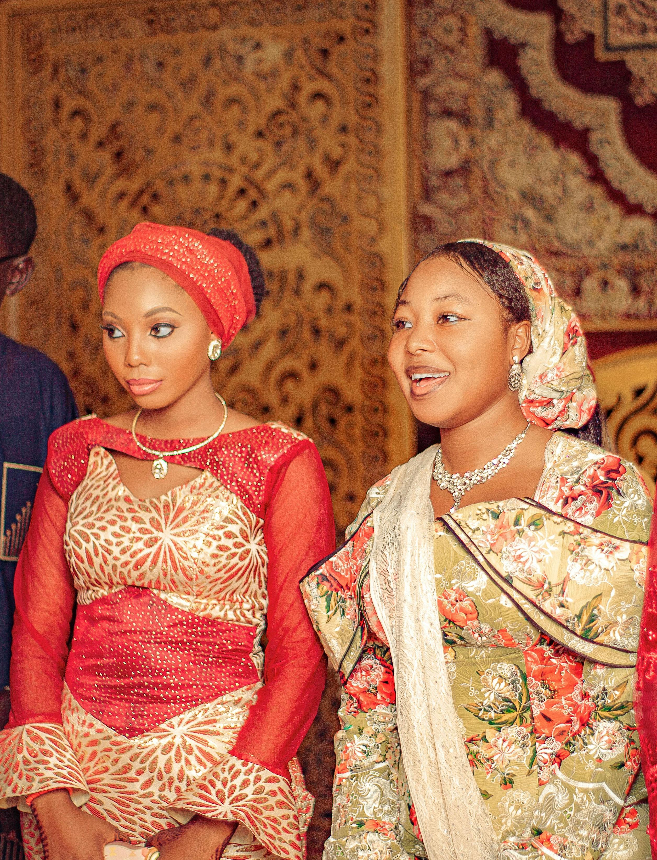 ingyenes Két nő színes hagyományos öltözékben egy kulturális ünnepségen fedett térben. Stockfotó