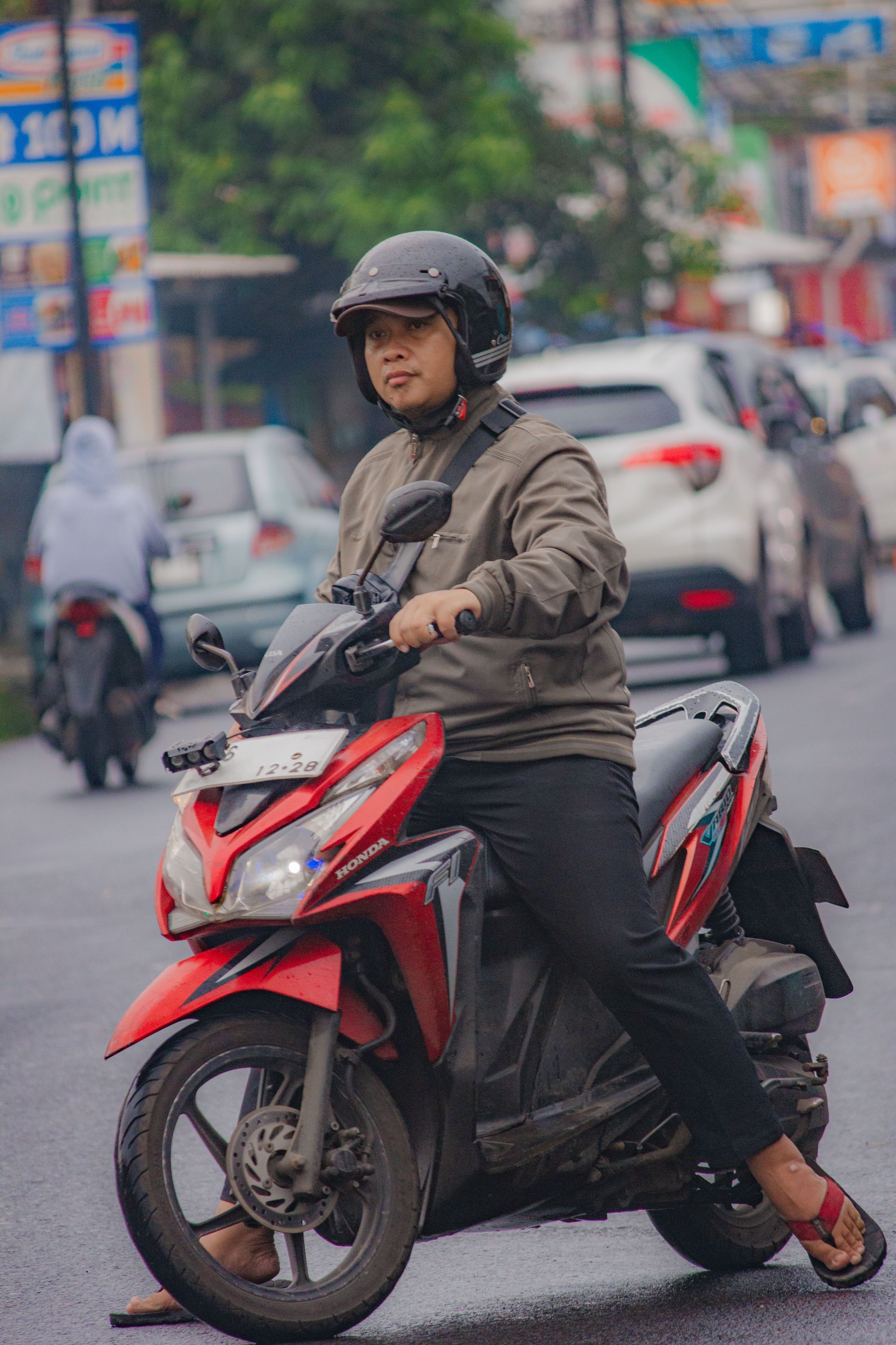 Person riding scooter on busy city street · Free Stock Photo