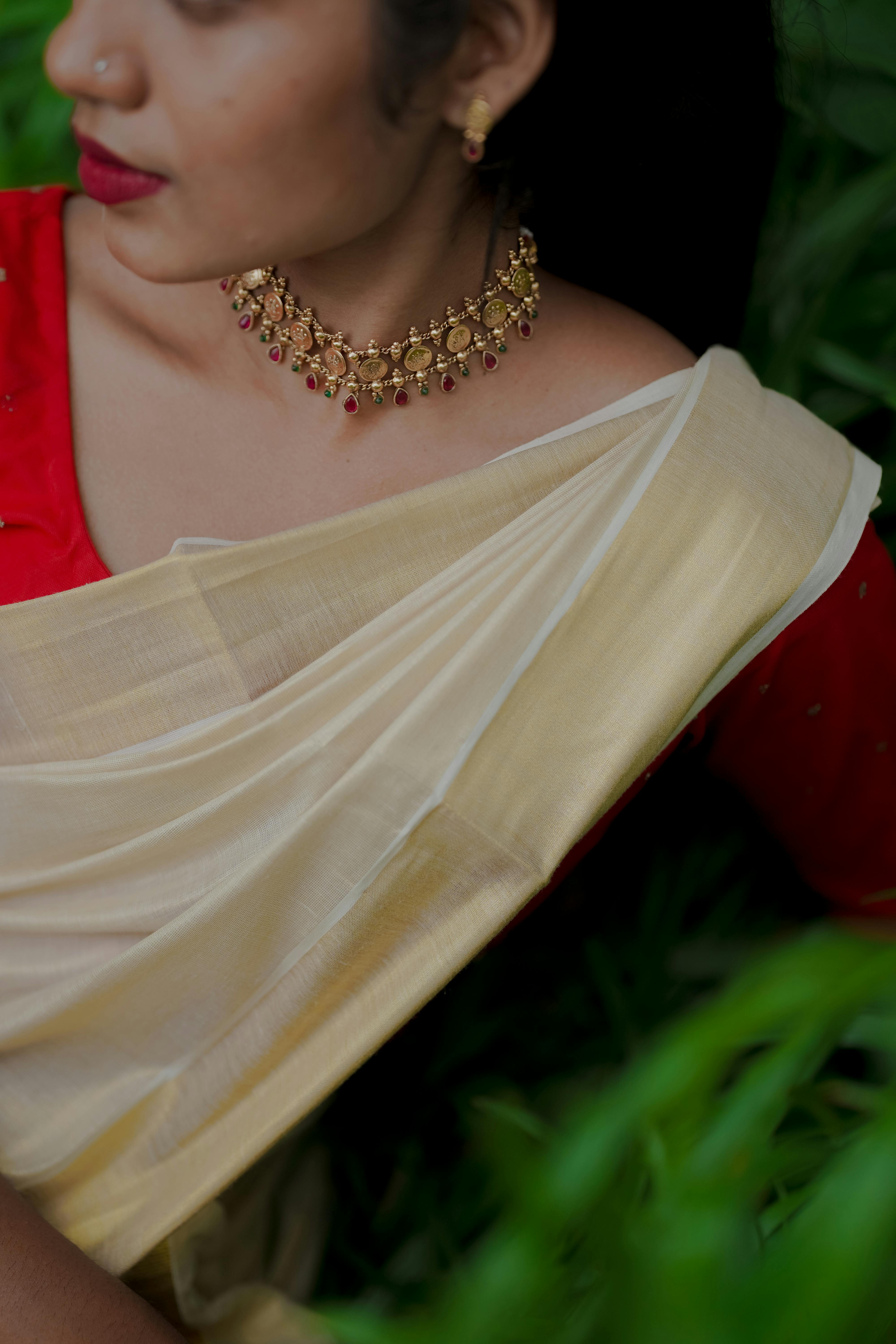 Free Close-up of a woman in a traditional sari with elegant jewelry showcasing cultural fashion. Stock Photo